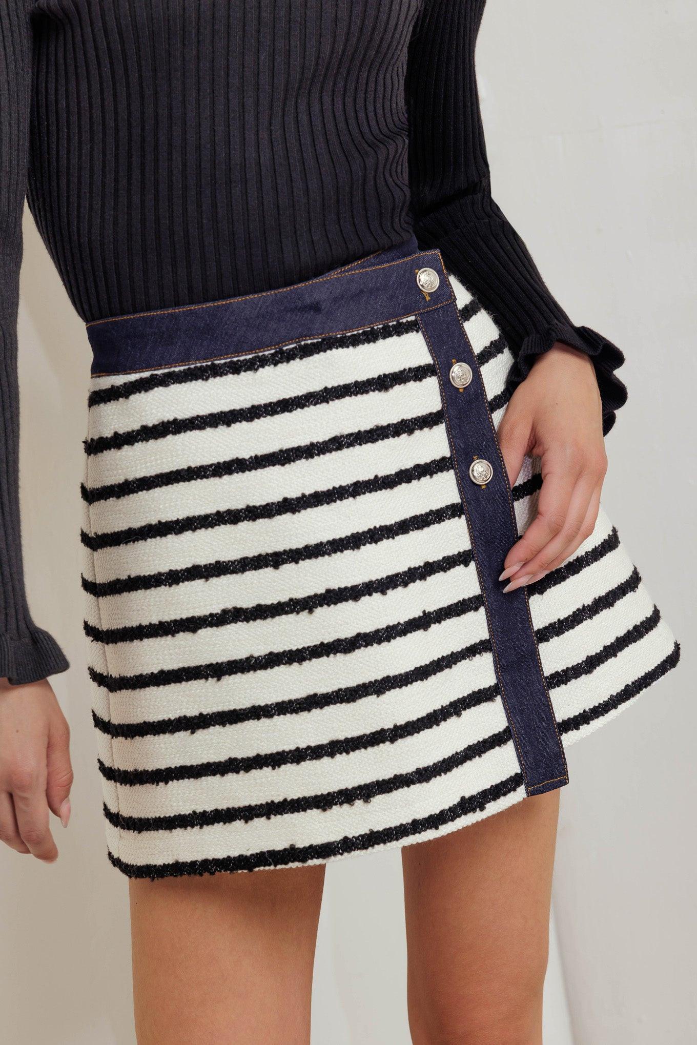 A textured striped woven skort featuring front button detail and denim trimmed edge.