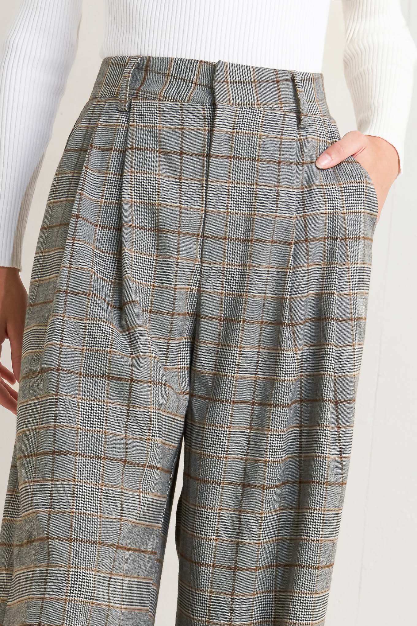 A woven plaid pant featuring front closure, side pockets and wide leg. 