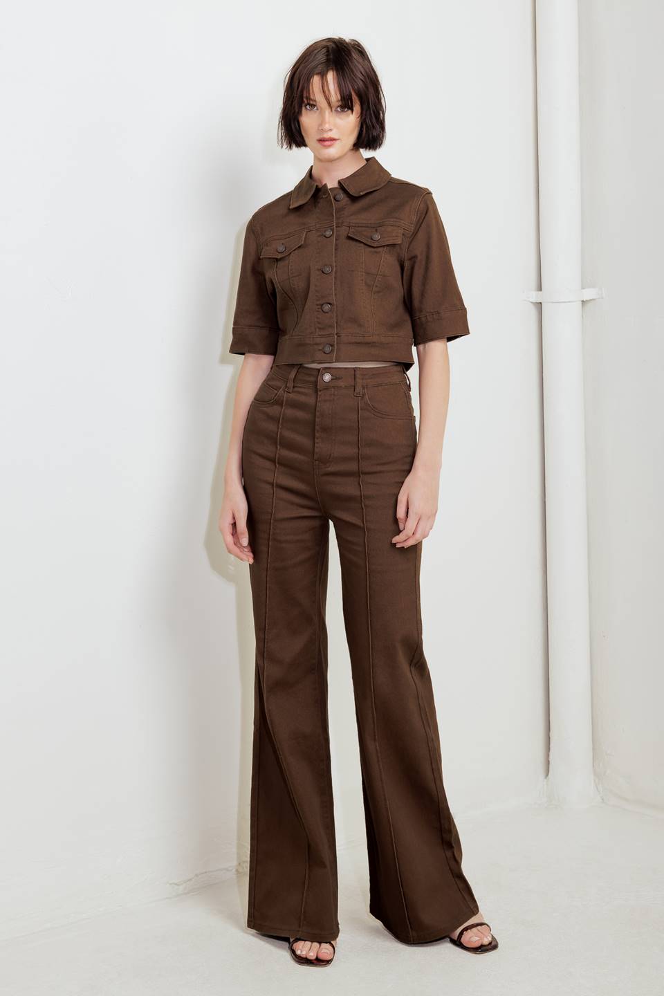 Woman wearing solid brown twill pants featuring front closure, front seam in the middle of each leg and pockets | FREEMARKET