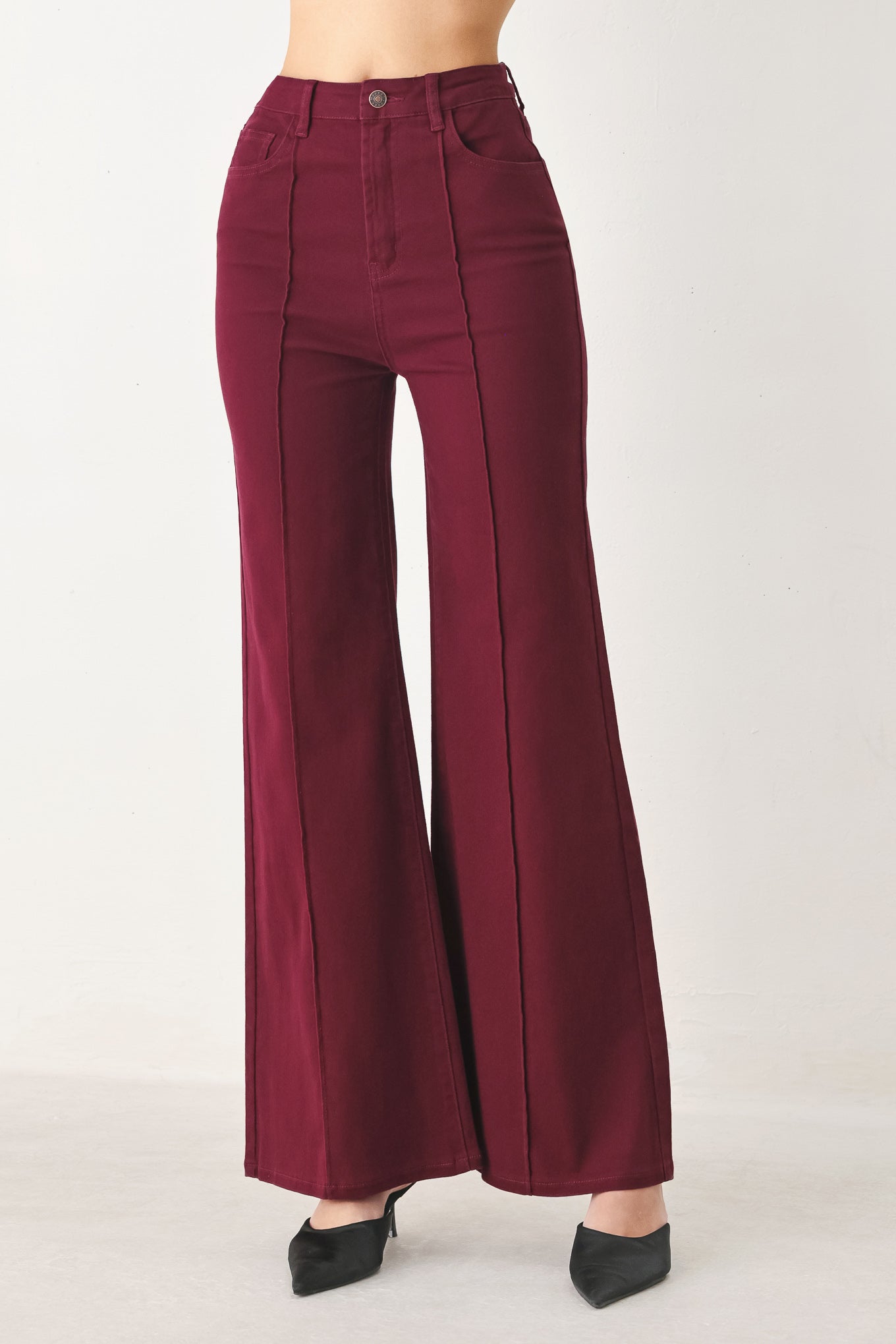Woman wearing solid burgundy twill pants featuring front closure, front seam in the middle of each leg and pockets | FREEMARKET
