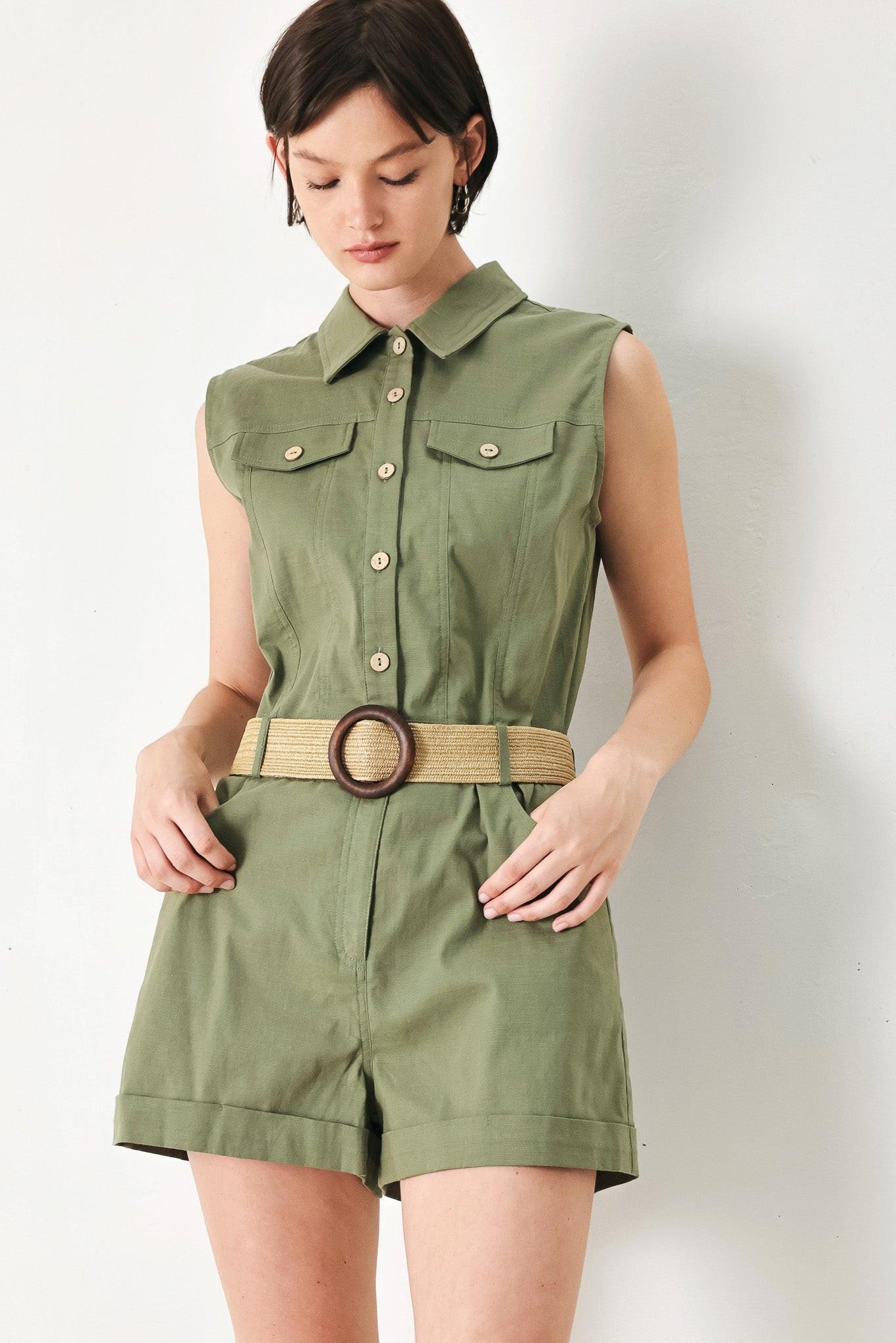 A solid woven romper featuring collar, sleeveless, front button zipper closure, pockets, cuffed hem and contrasting belt