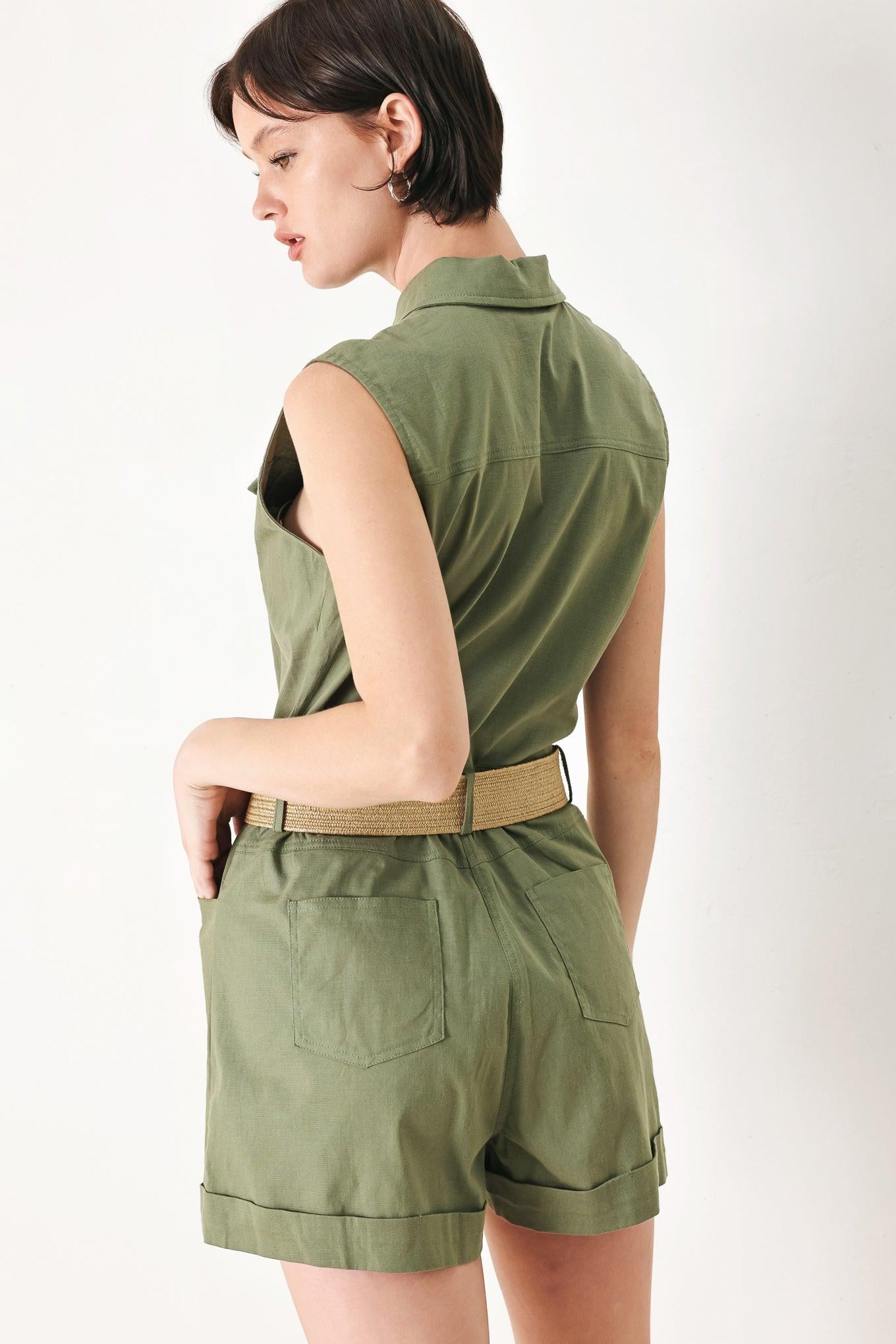 A solid woven romper featuring collar, sleeveless, front button zipper closure, pockets, cuffed hem and contrasting belt