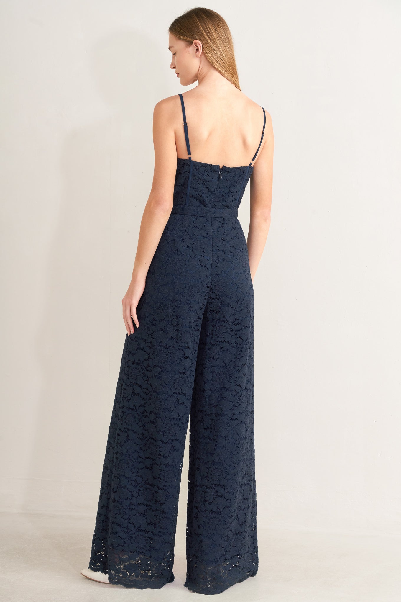 Navy lace jumpsuit worn by a model on a plain background