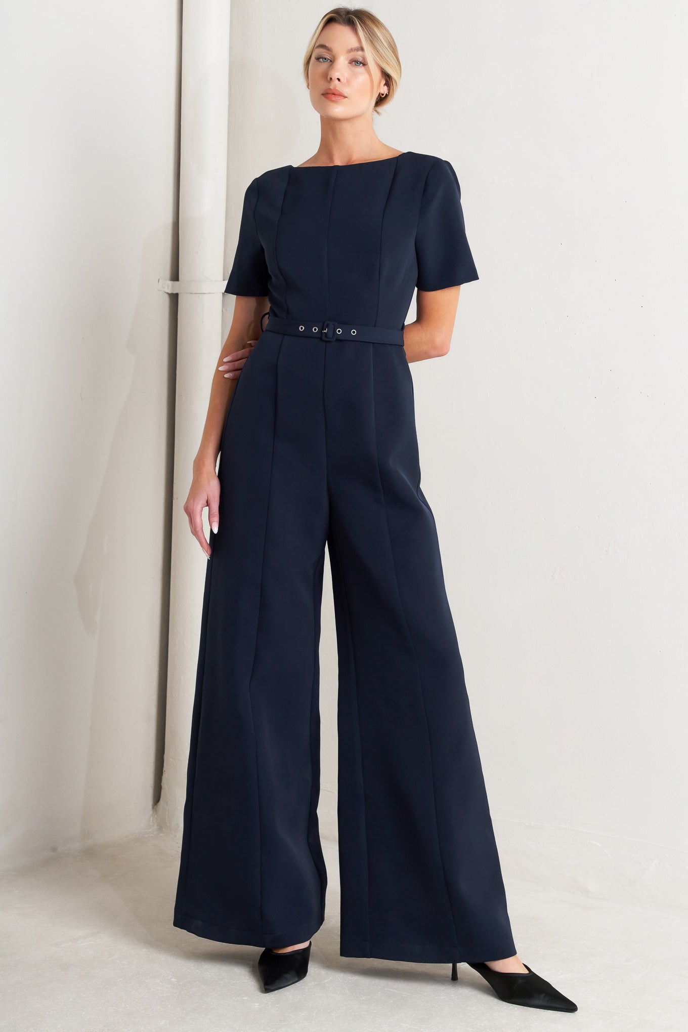 A solid woven jumpsuit featuring wide neckline, short sleeve, self belt, wide leg, V back and zipper closure
Self : 95% Polyester 5% Spandex
Size & Fit
- Model is 5`8" And Wearing Size Small
- Measurements Taken From Size Small
- Approx. Length: 60"
