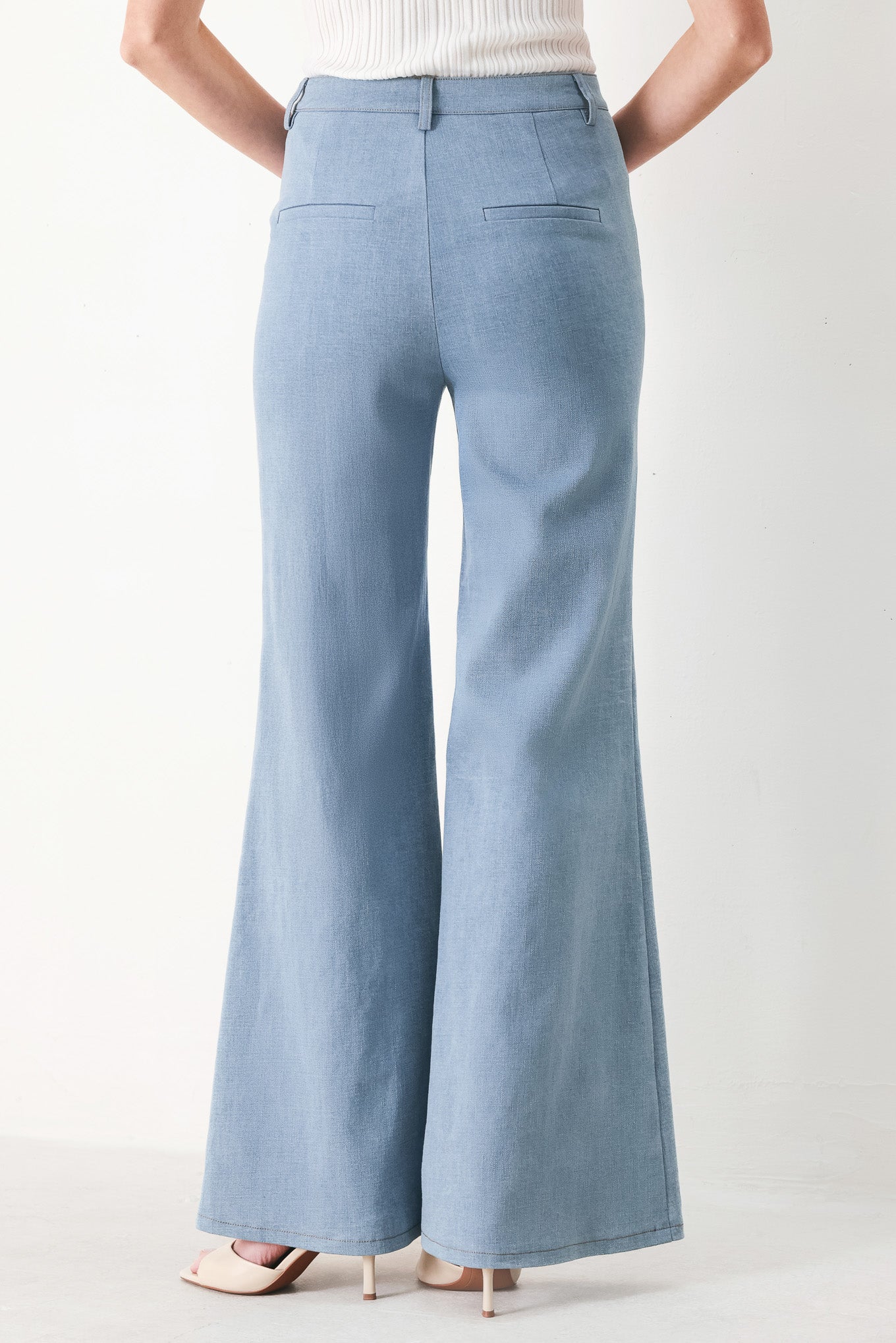 Woman wearing light blue boot cut pants with front closure | FREEMARKET | Flying Tomato