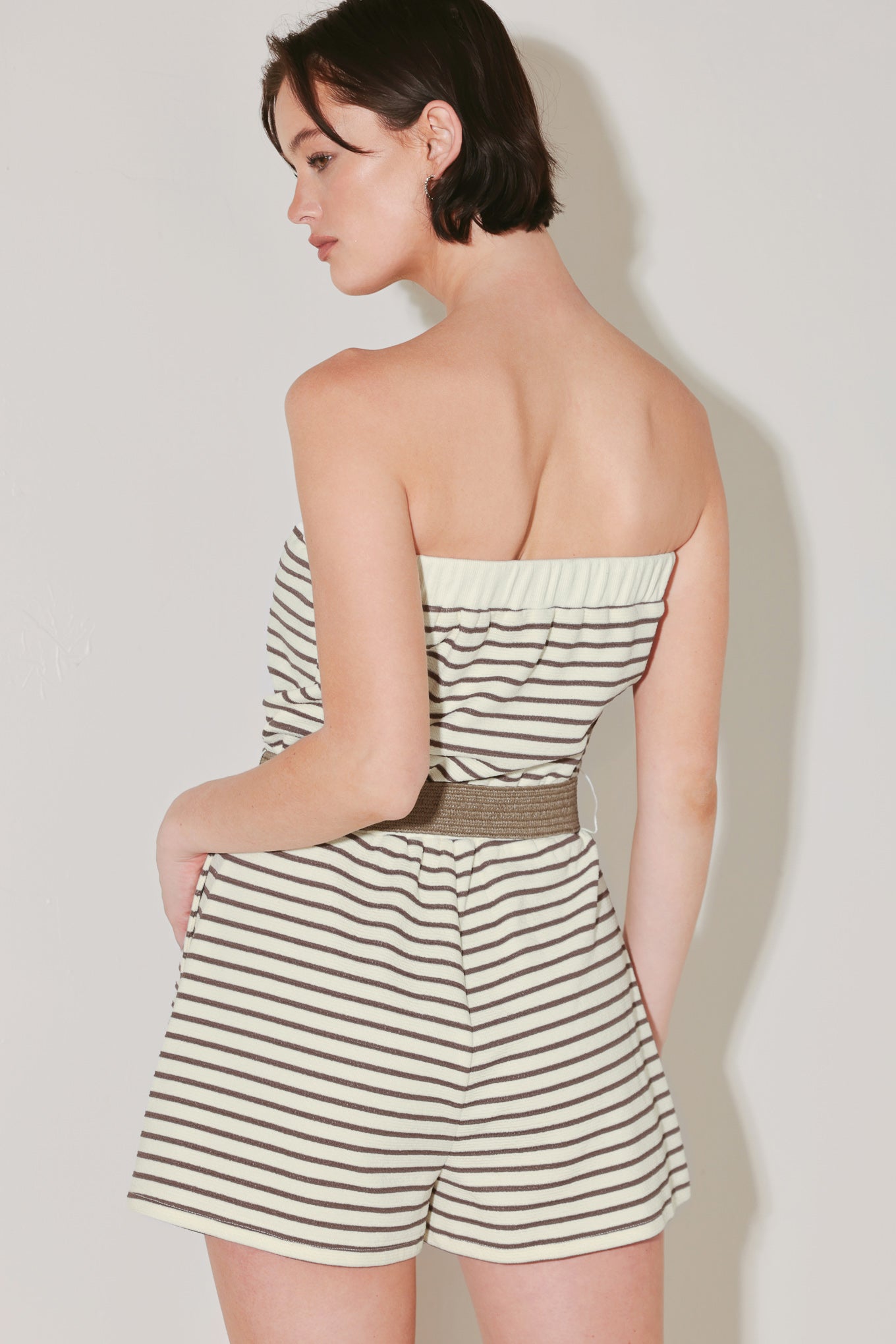 Woman wearing a strapless striped knit romper featuring strapless with elastic opening, elastic waist, side pocket and contrasting belt | FREEMARKET | Flying Tomato
