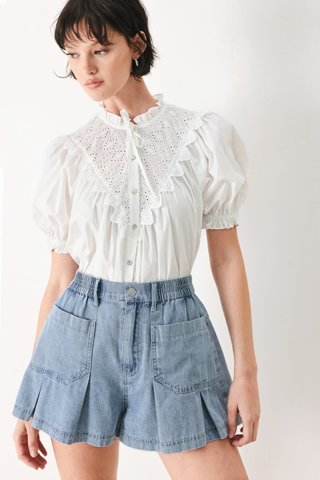 Woman wearing washed light denim short featuring elastic waist, front closure, front pockets and pleats with wide leg | FREEMARKET