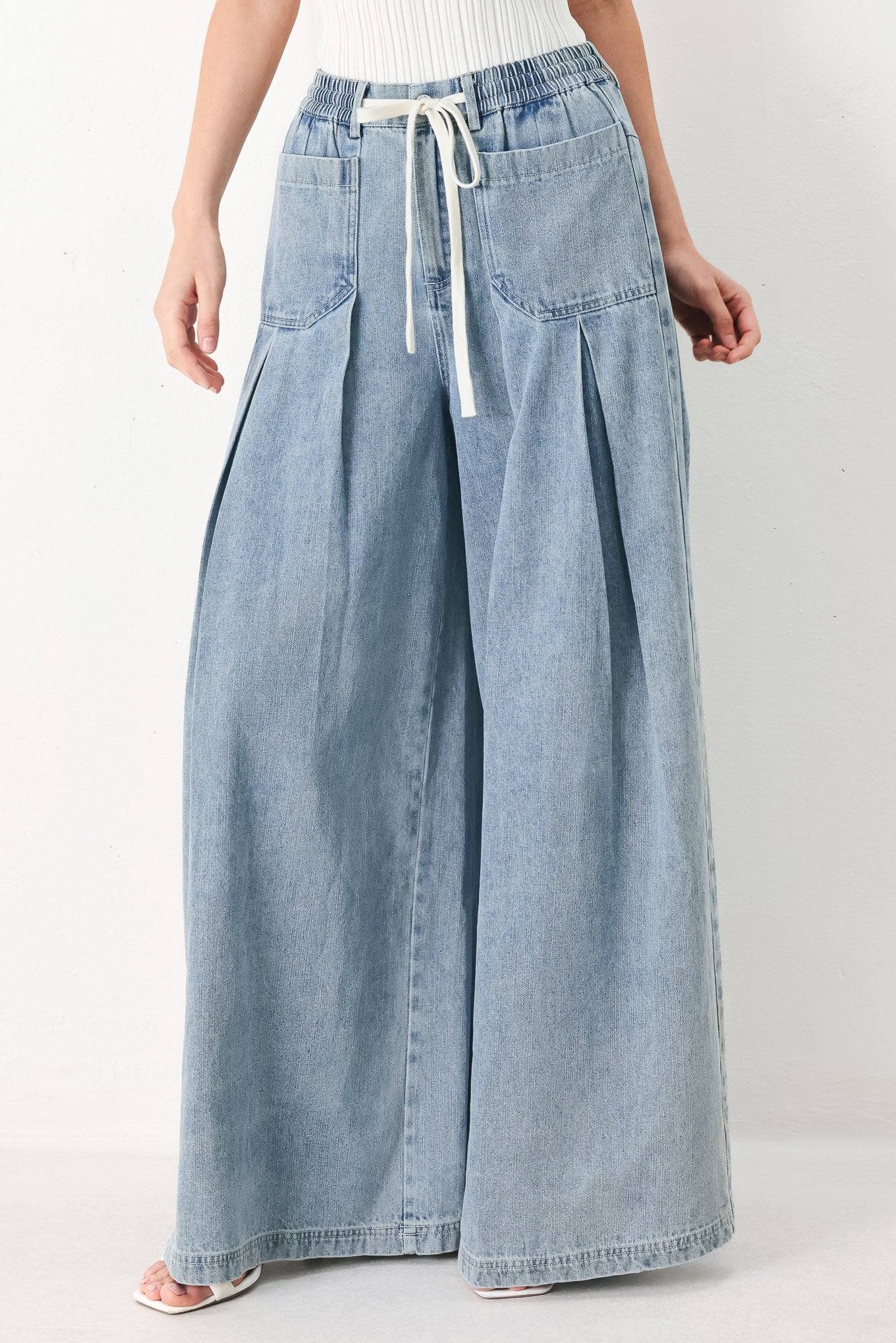 Woman wearing a light blue denim wide-leg pants with a drawstring waist | FREEMARKET