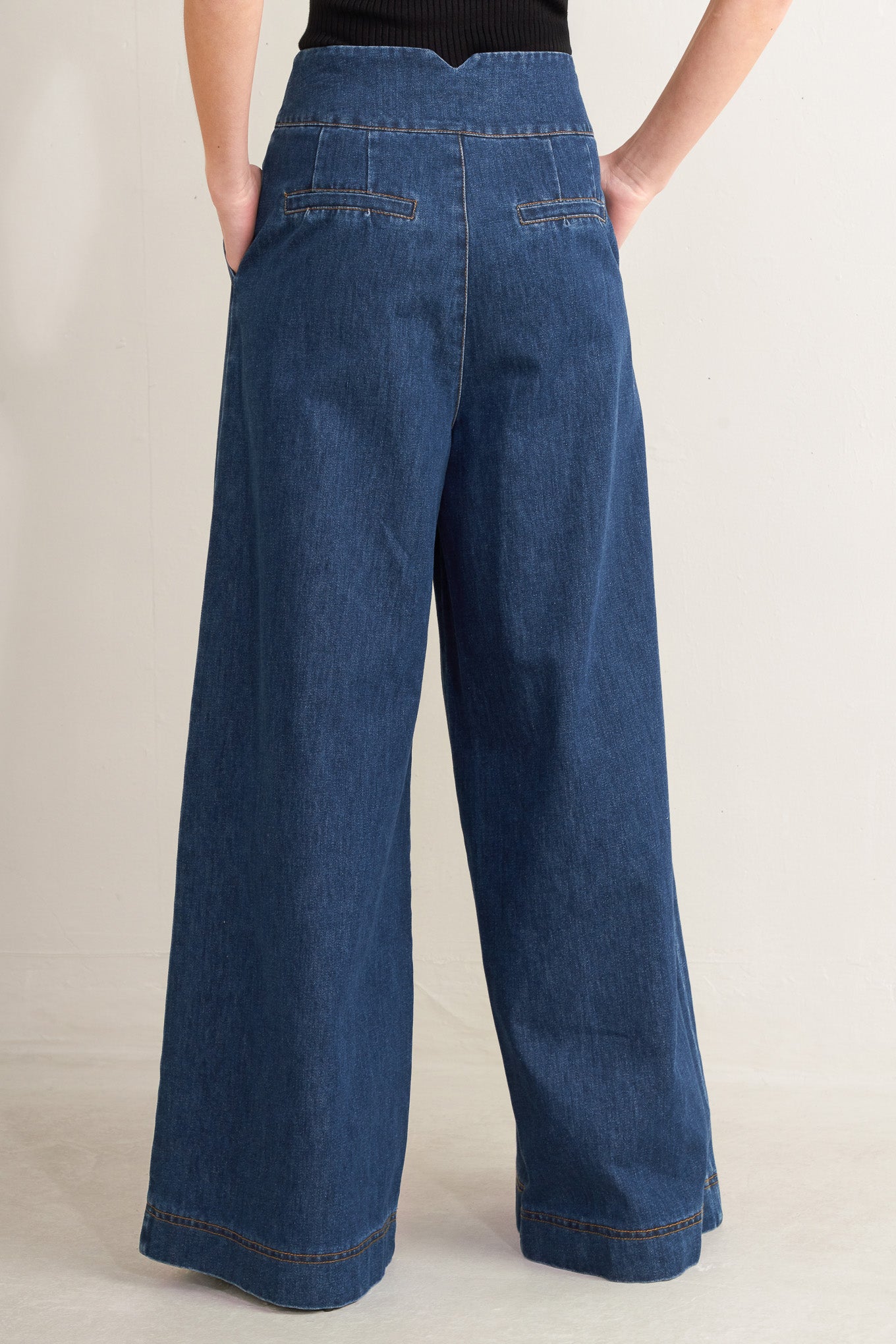 Blue wide-leg jeans worn by a person on a plain background