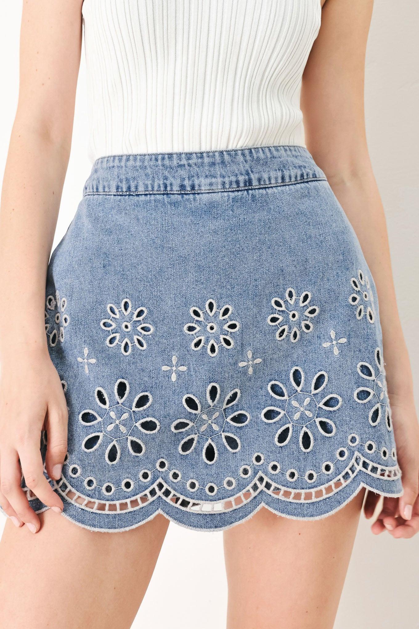A washed denim skort with eyelet cut out hem and back zipper closure