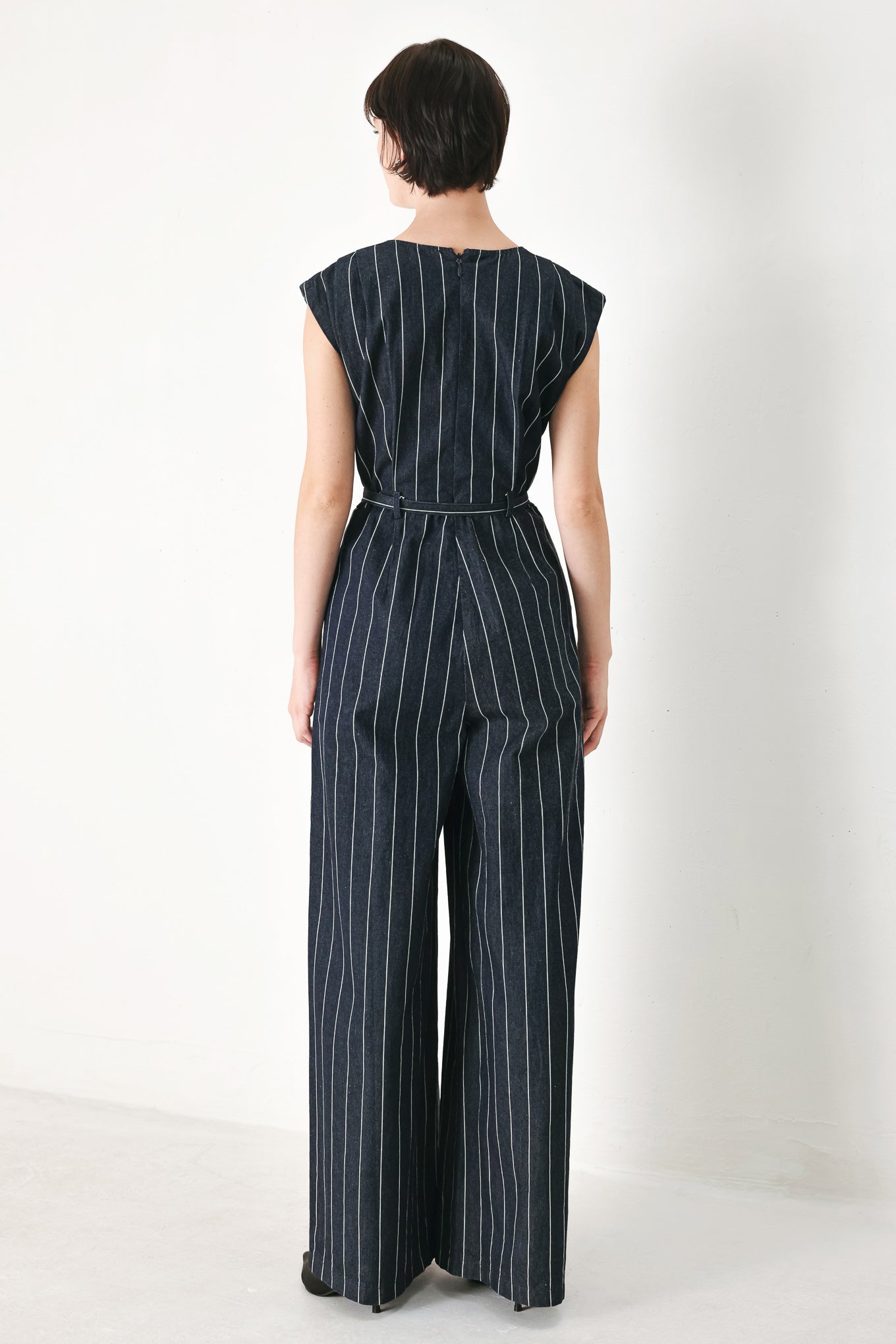 A striped woven jumpsuit featuring V neckline, short sleeve, self skinny belt, wide leg and back zipper closure