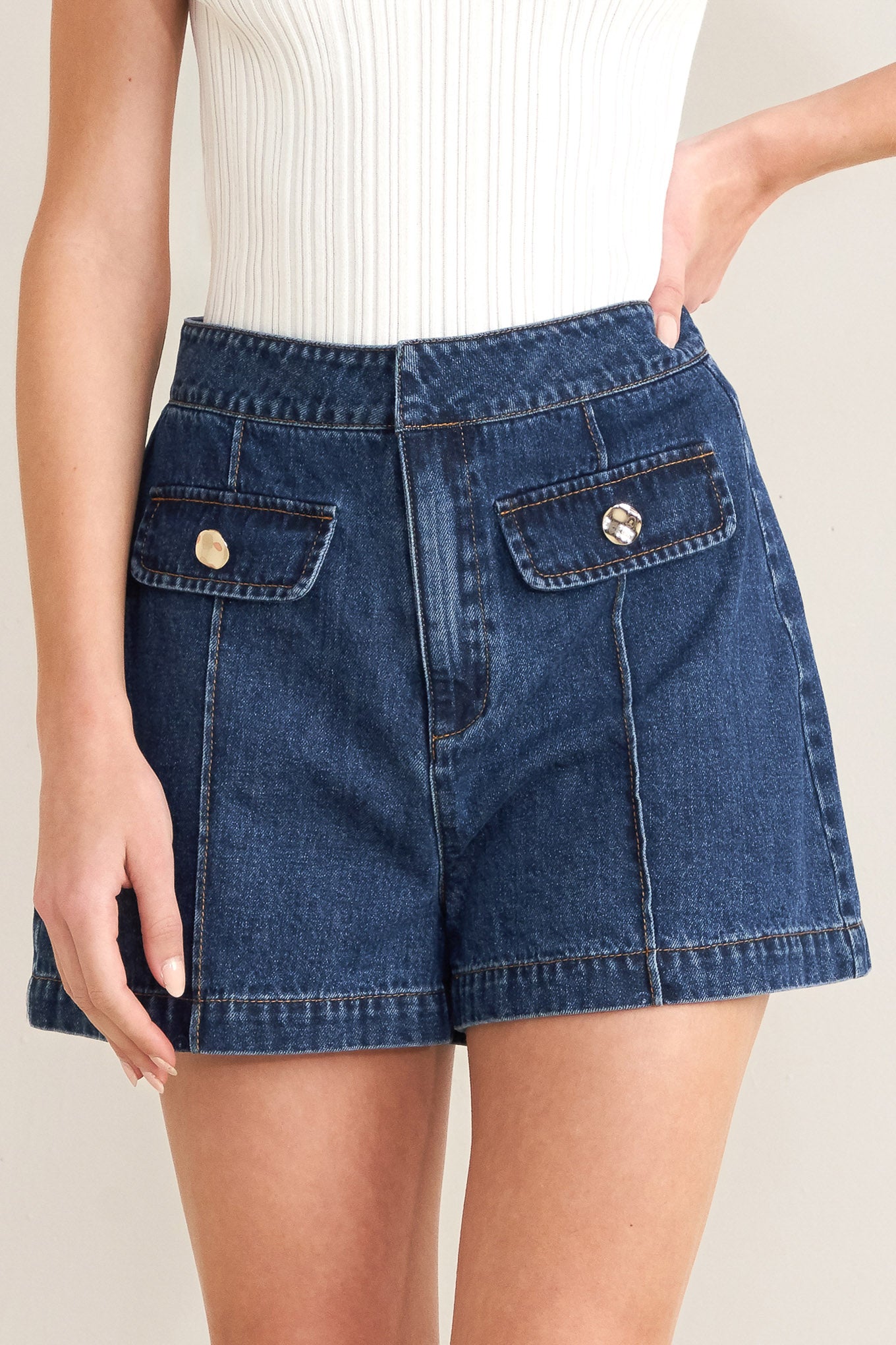 Denim shorts with button details on a neutral background