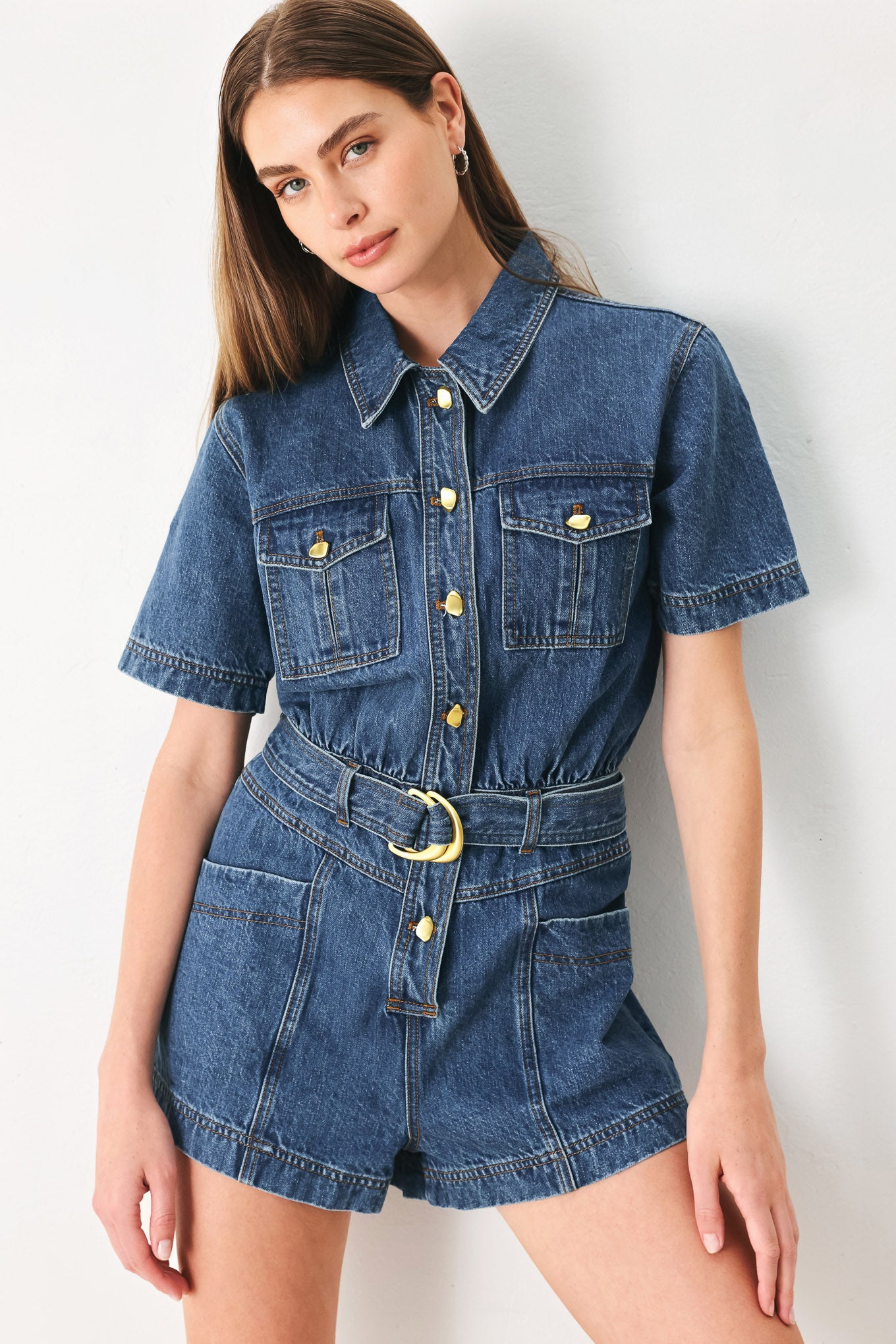 Woman wearing a denim romper featuring collar, button down closure, short sleeve, pockets and belt | FFREEMARKET | Flying Tomato
