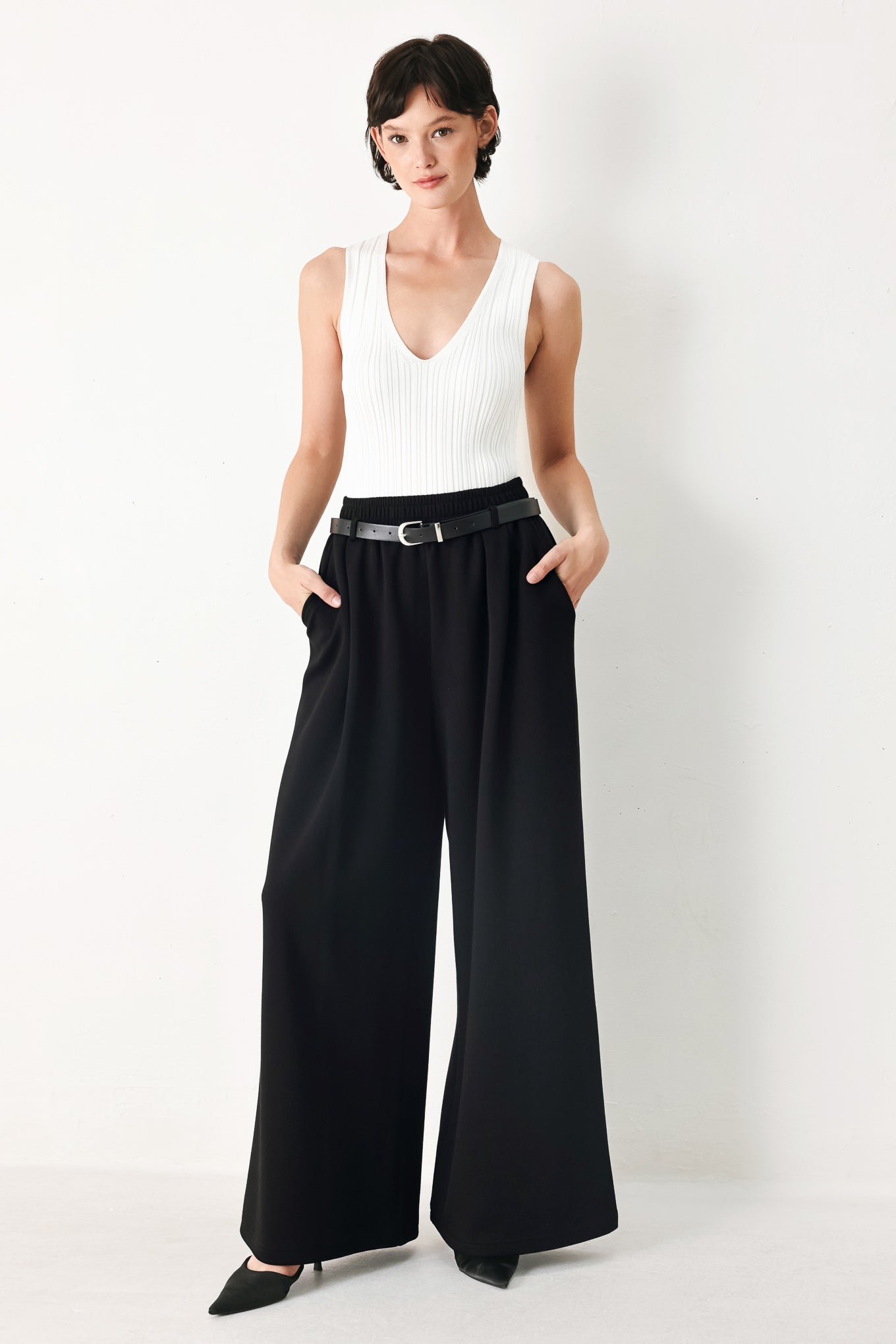Woman wearing black wide-leg pants with a self tie belt | FREEMARKET