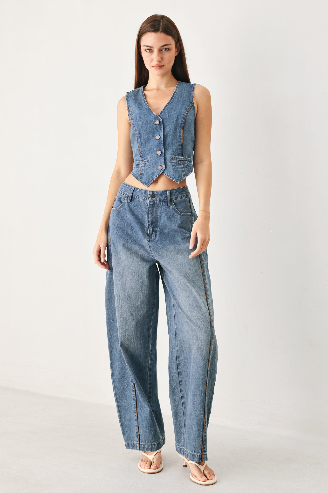 Woman wearing light blue denim balloon pant with front closure, pockets and piping detail | FREEMARKET