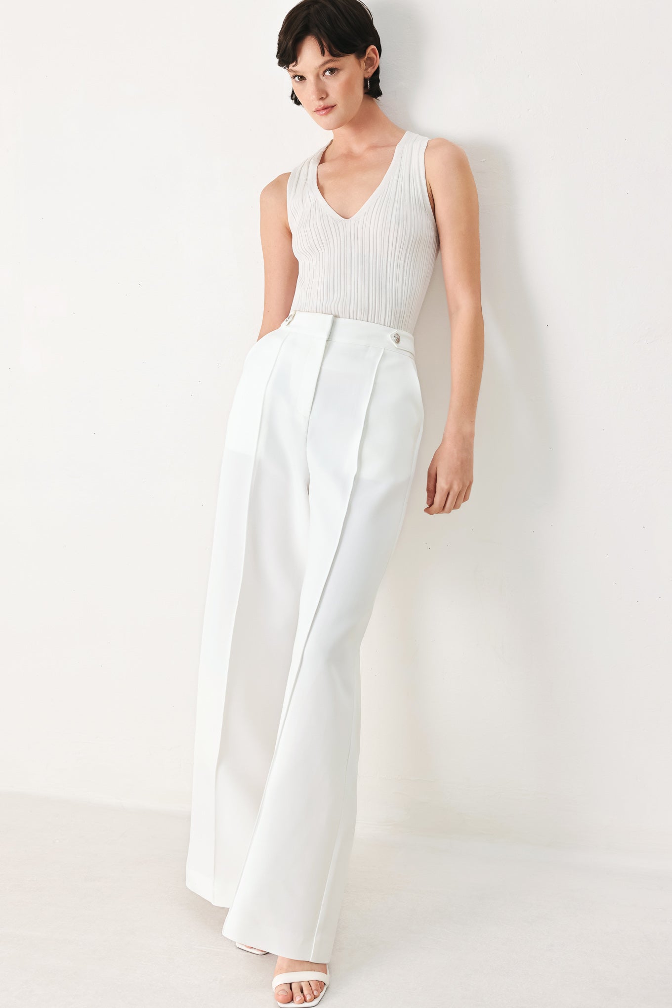 Woman wearing white wide-leg pants with side pockets and front closure | FREEMARKET