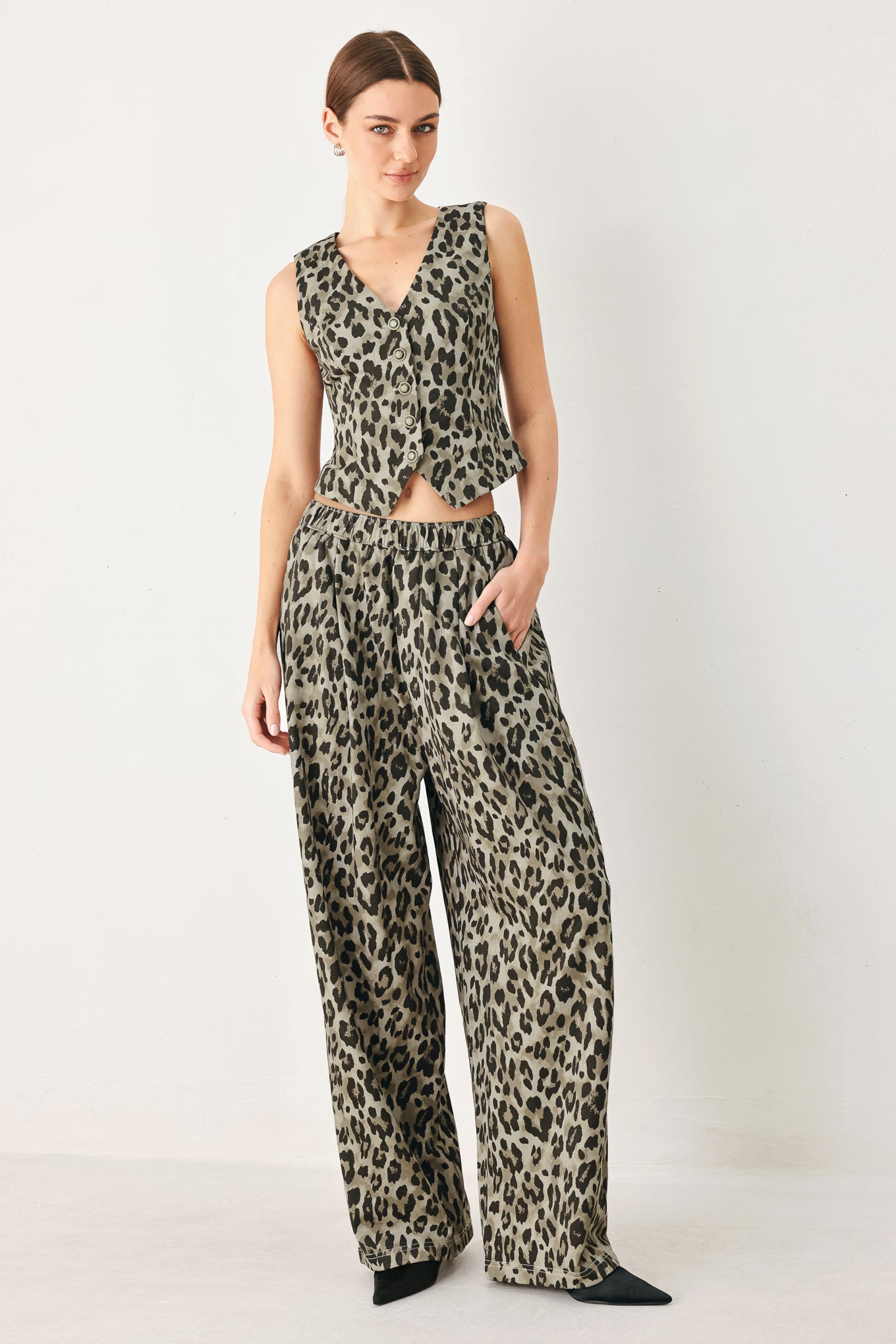Woman wearing a brown and black leopard print pants with elastic waist | FREEMARKET