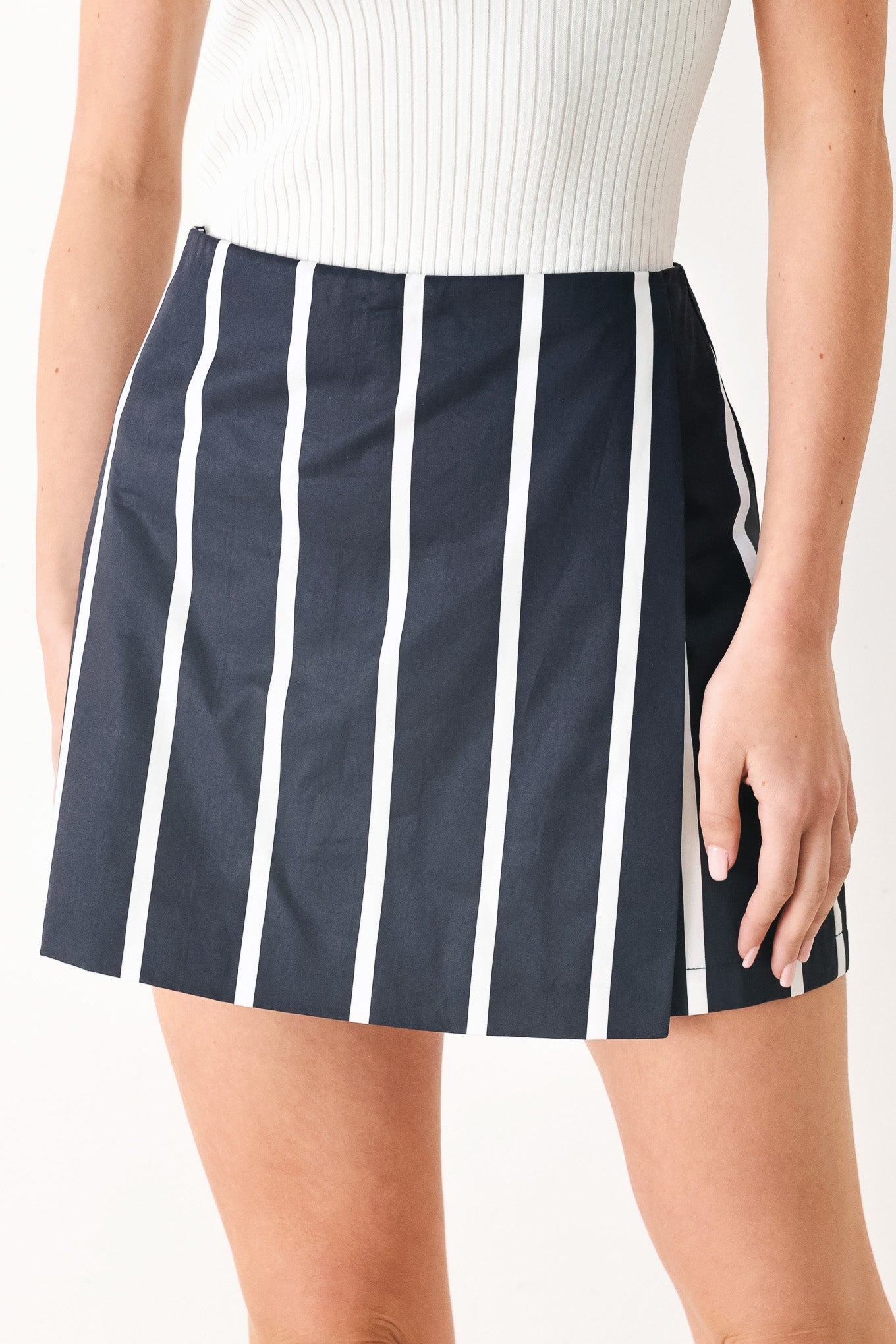 Woman wearing a navy blue and white striped skort with back zipper closure | FREEMARKET