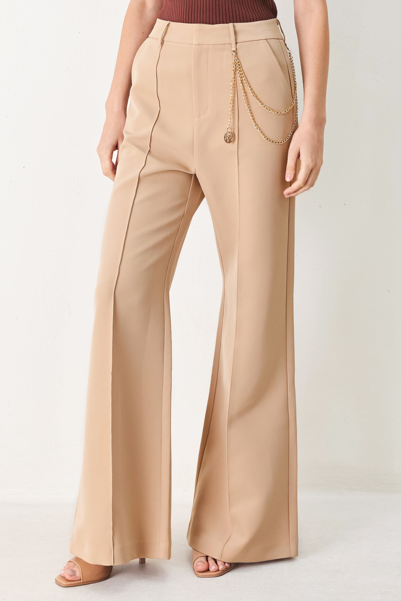 Woman wearing camel beige wide-leg pants with a chain detail on the side | FREEMARKET