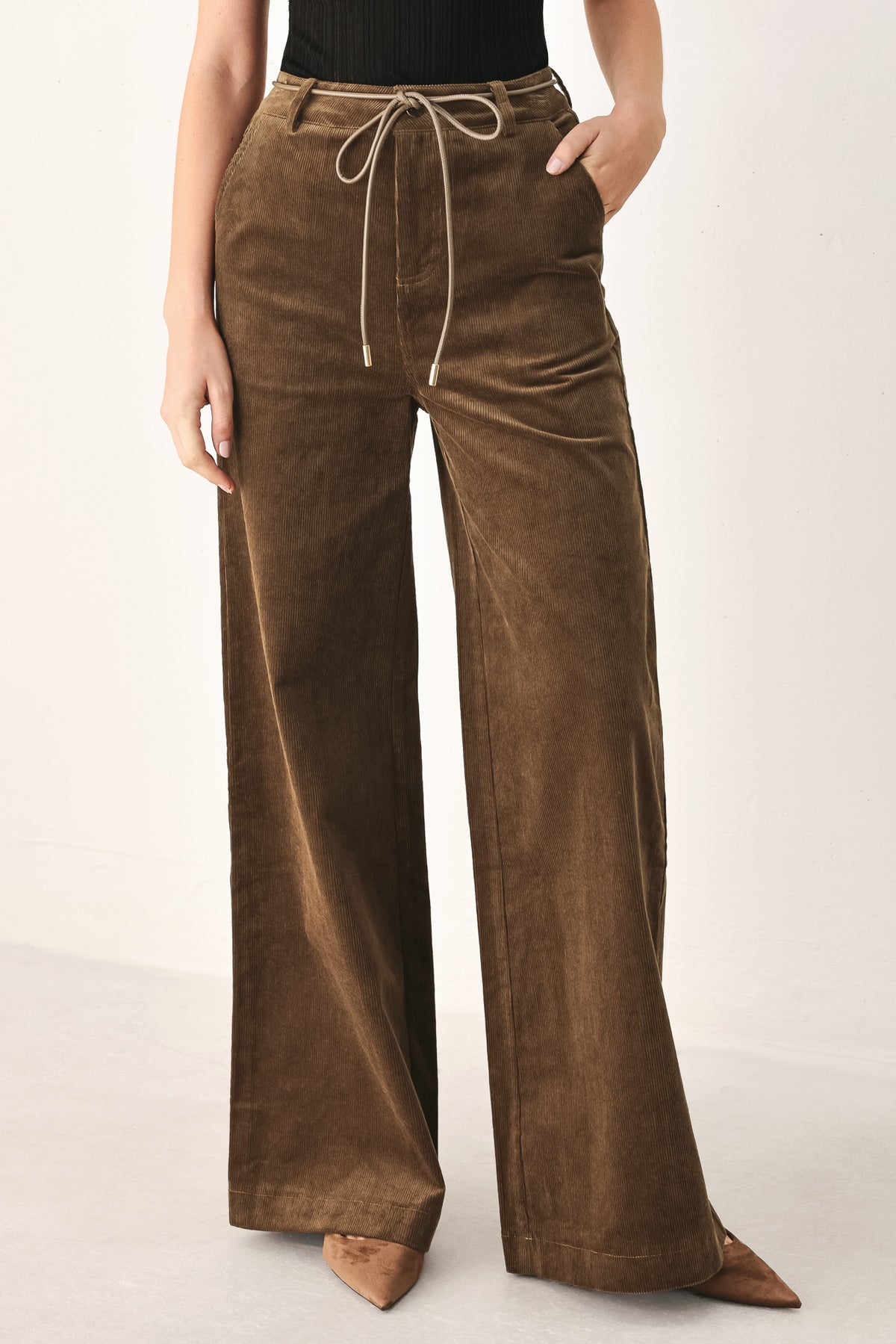 A model wearing high-waisted, wide-leg brown corduroy pants with a drawstring waist | FREEMARKET