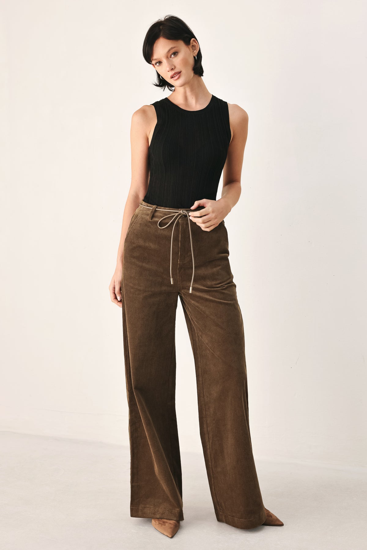 A model wearing high-waisted, wide-leg brown corduroy pants with a drawstring waist | FREEMARKET