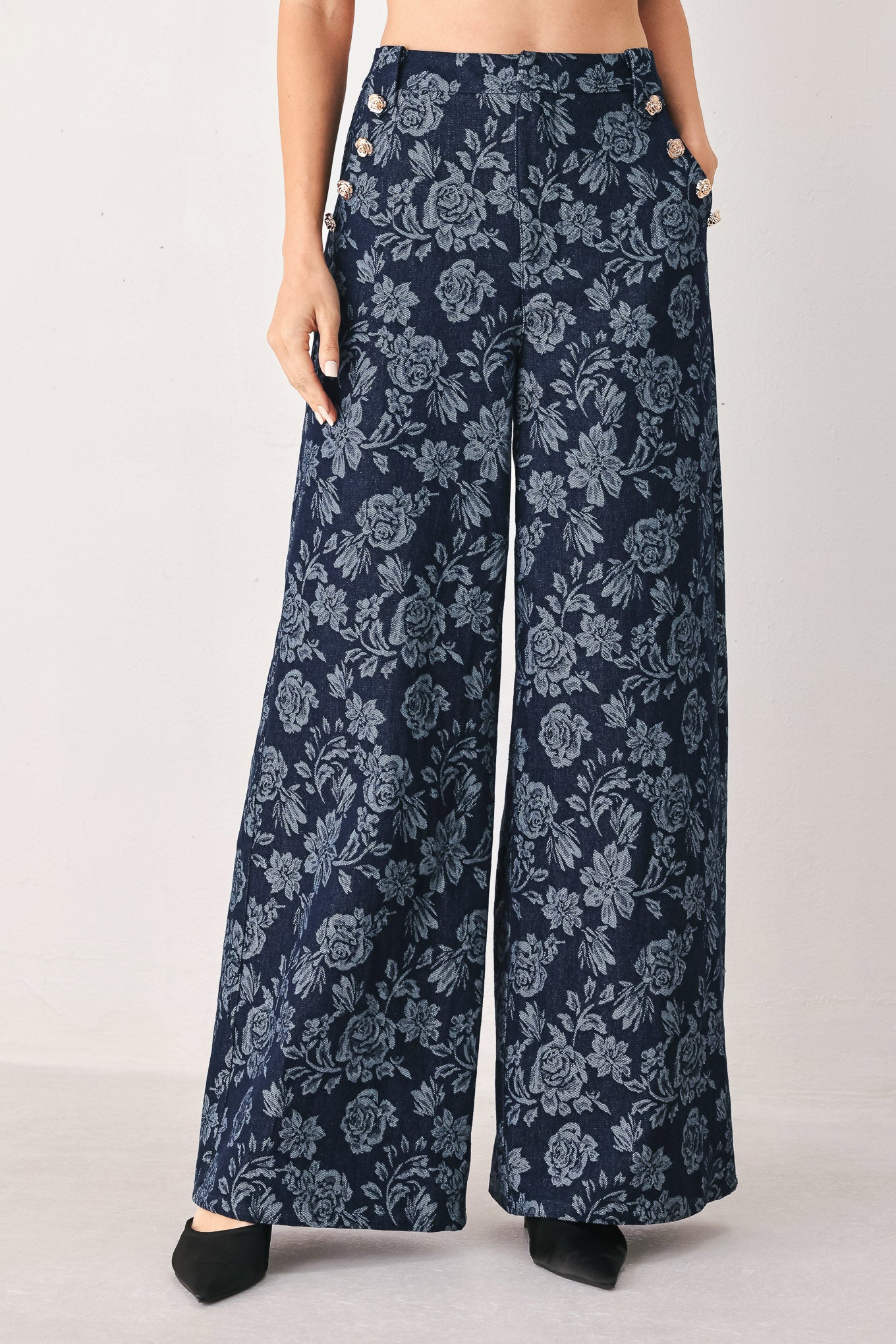 A woman wearing navy wide-leg jacquard pants with a light blue floral pattern and decorative buttons on the side | FREEMARKET