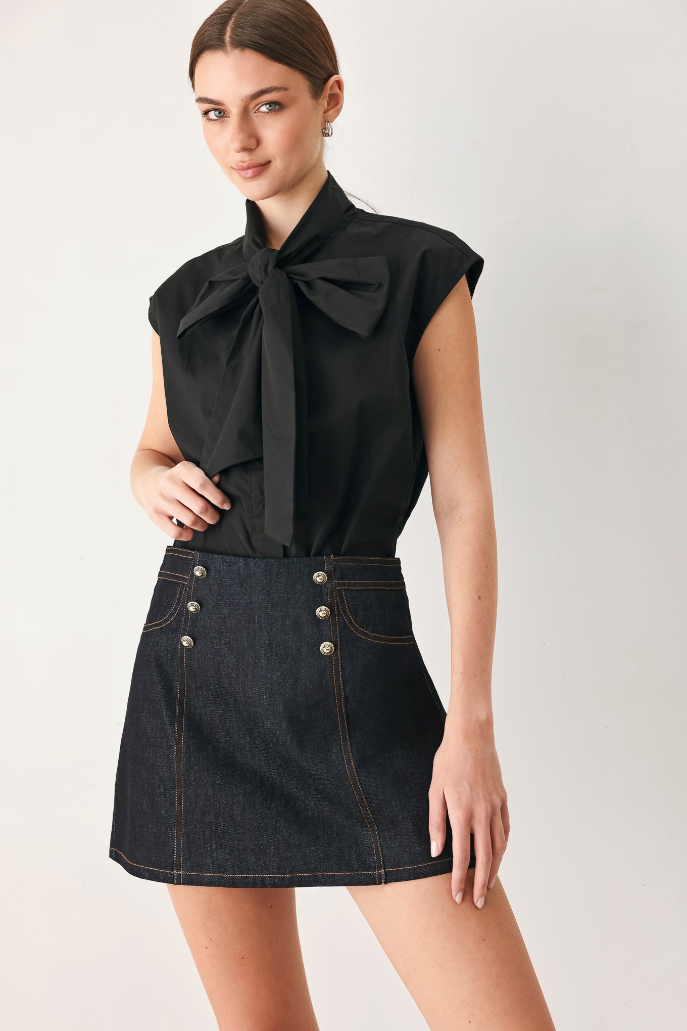 Woman wearing a dark lightweight denim skort with front button detail, pockets and back zipper closure | FREEMARKET