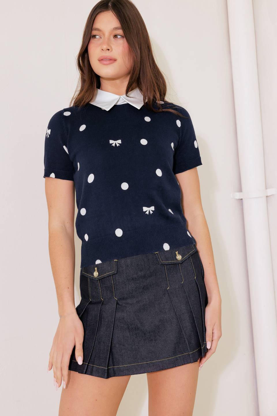 A sweater knit top featuring woven collar back button closure and short sleeve