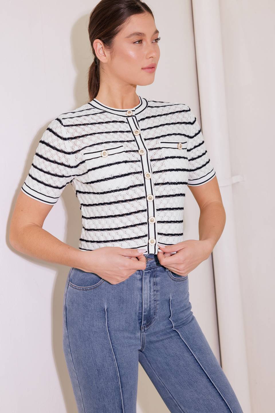 A sweater knit cardigan featuring round neckline, short sleeve, front pocket and button down