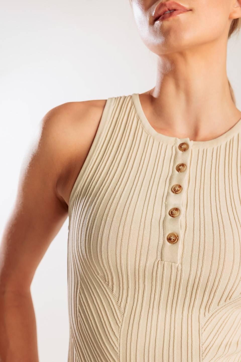 A sleeveless, sweater knit tank top with front button down
