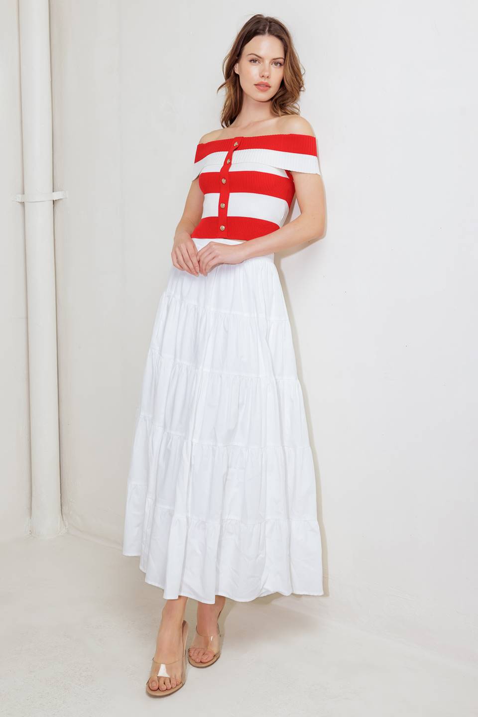 A red and white striped sweater knit crop top featuring off shoulder neckline and button down detail