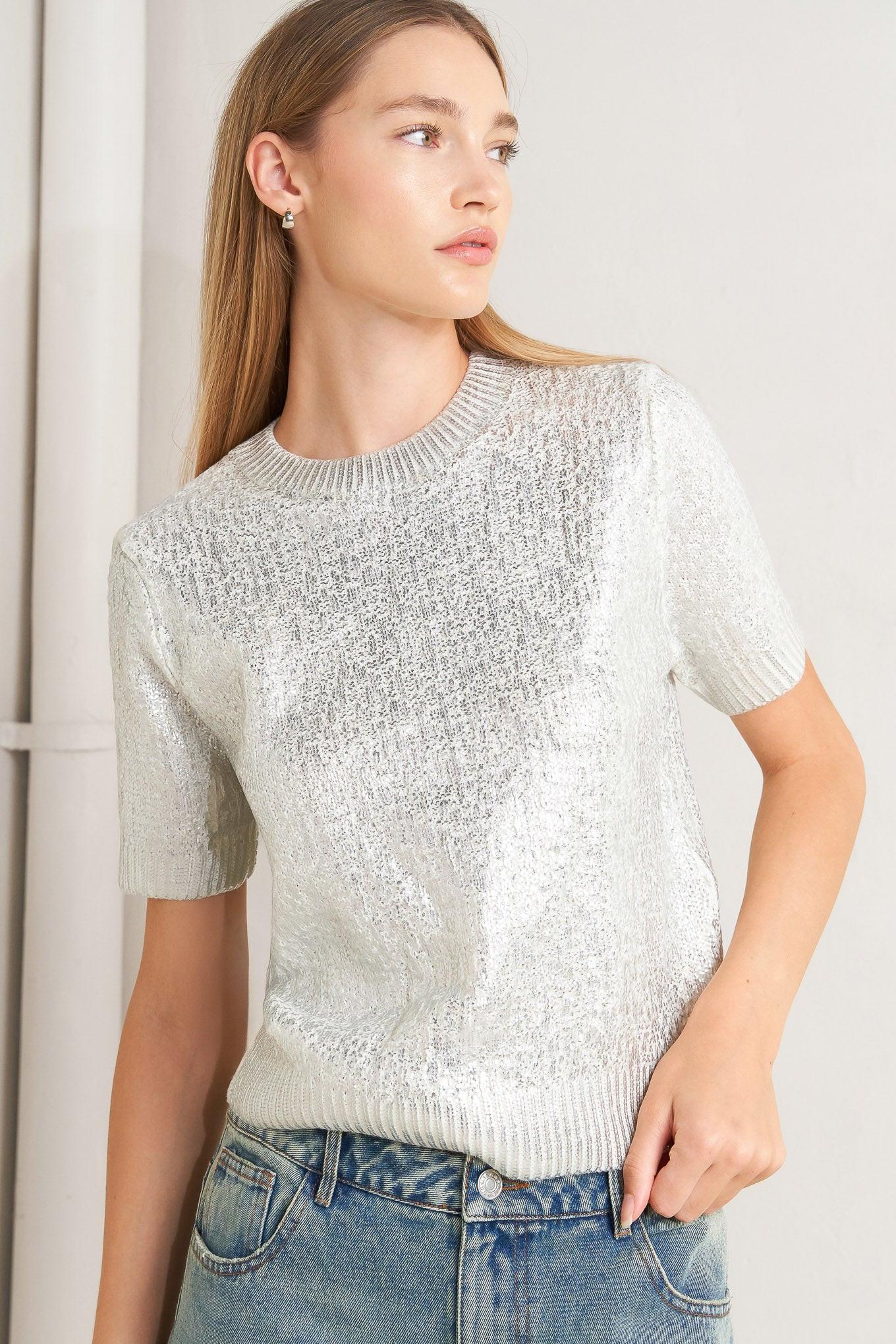 A foiled sweater knit top featuring crew neckline and short sleeve