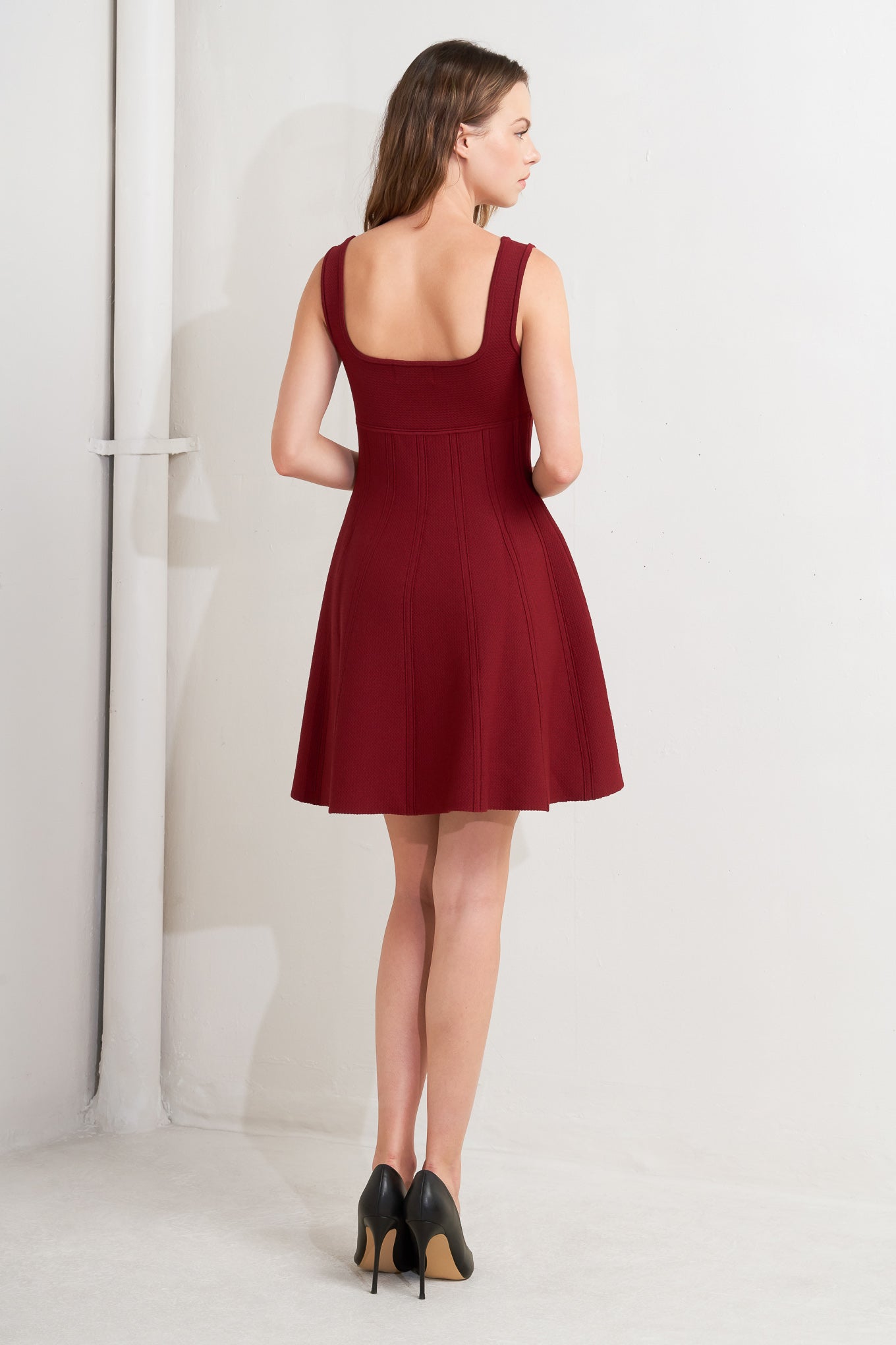 A solid sweater knit mini dress featuring square neckline, sleeveless and full skirt