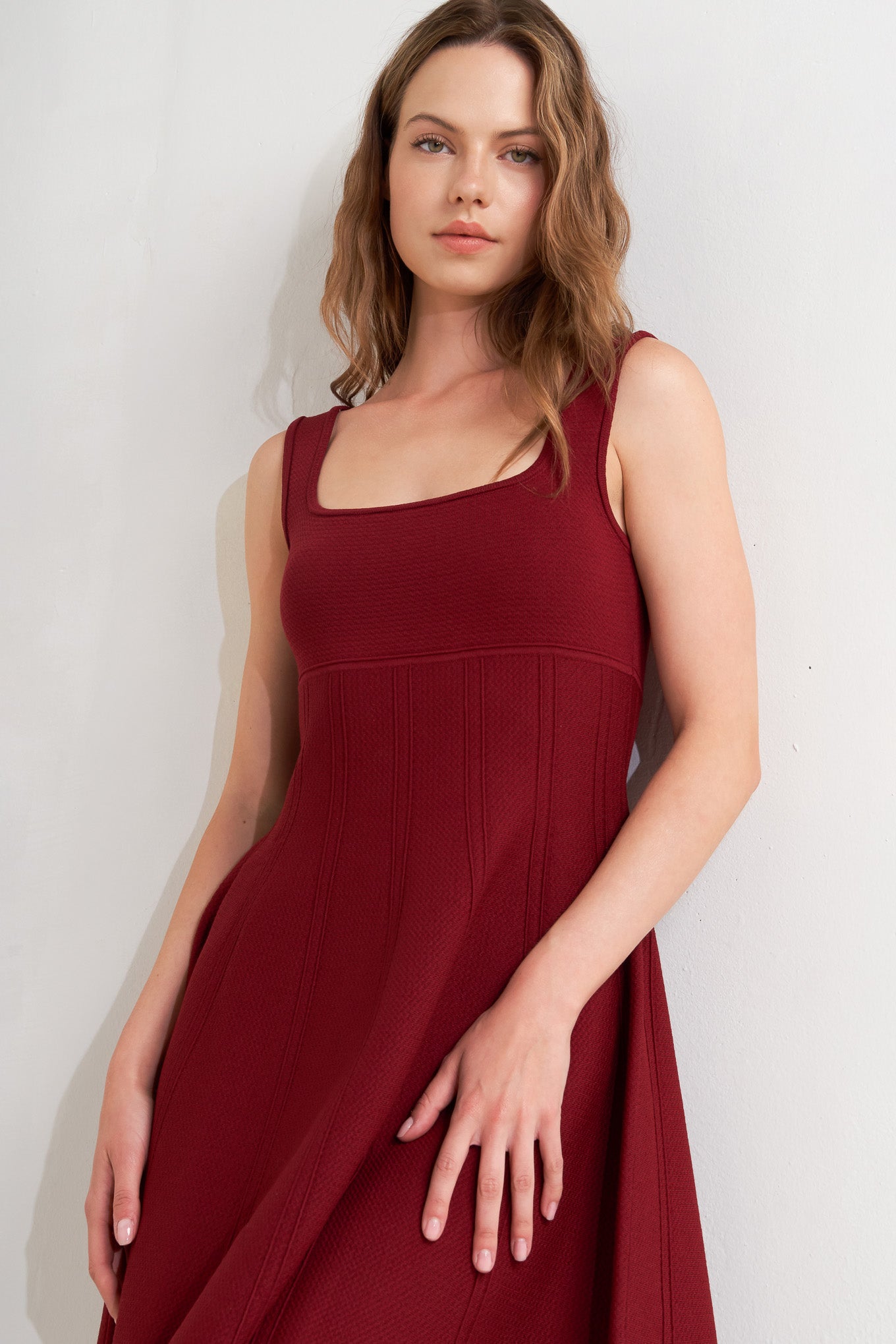 A solid sweater knit mini dress featuring square neckline, sleeveless and full skirt