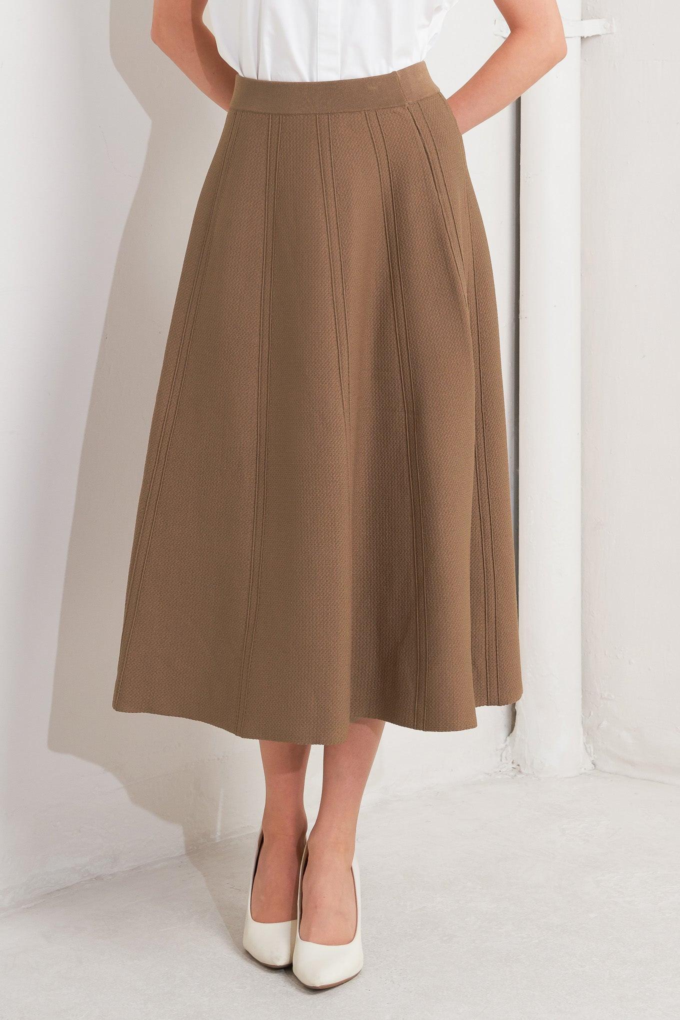 Person wearing a brown skirt and white shoes on a white background - Flying Tomato