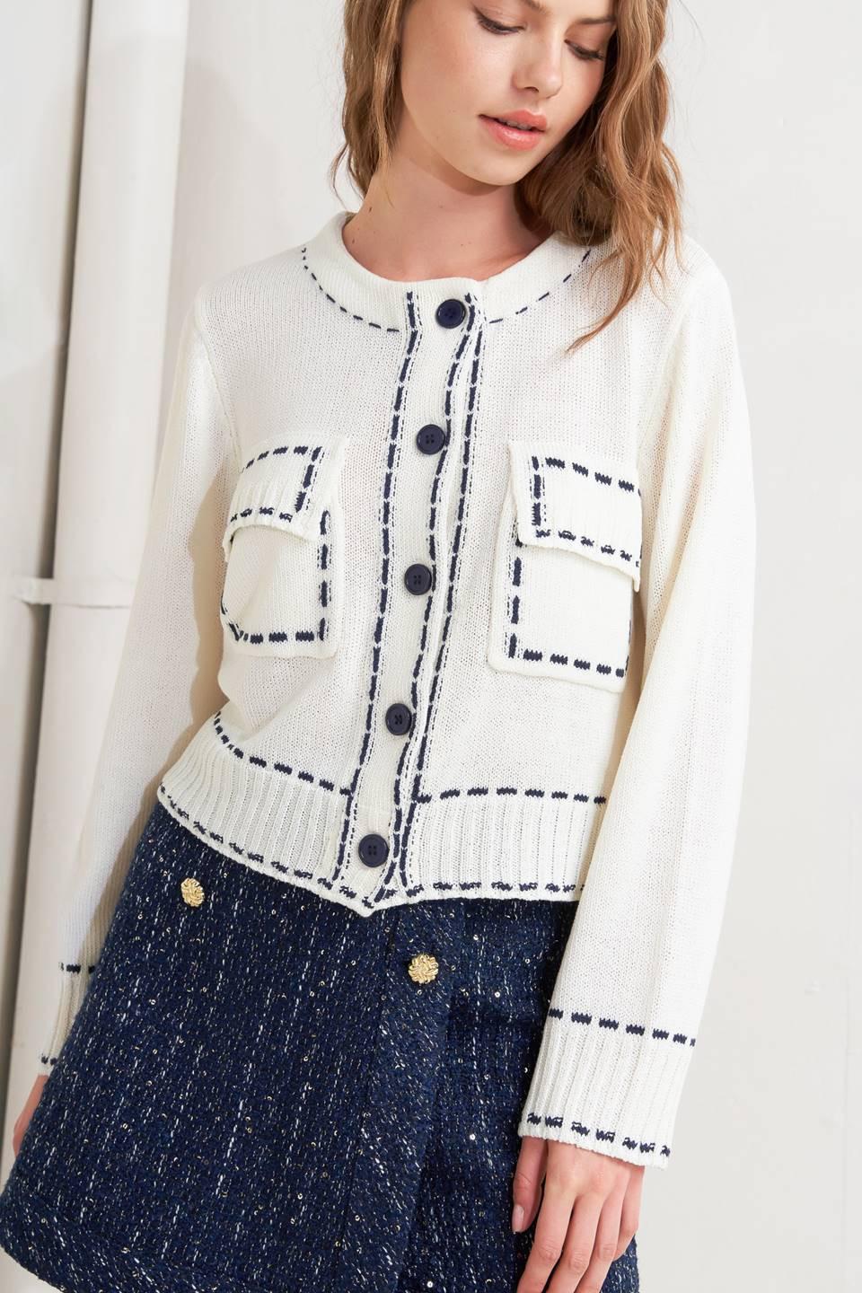 A sweater knit top featuring round neckline, button down, long sleeve and stitch edge detail