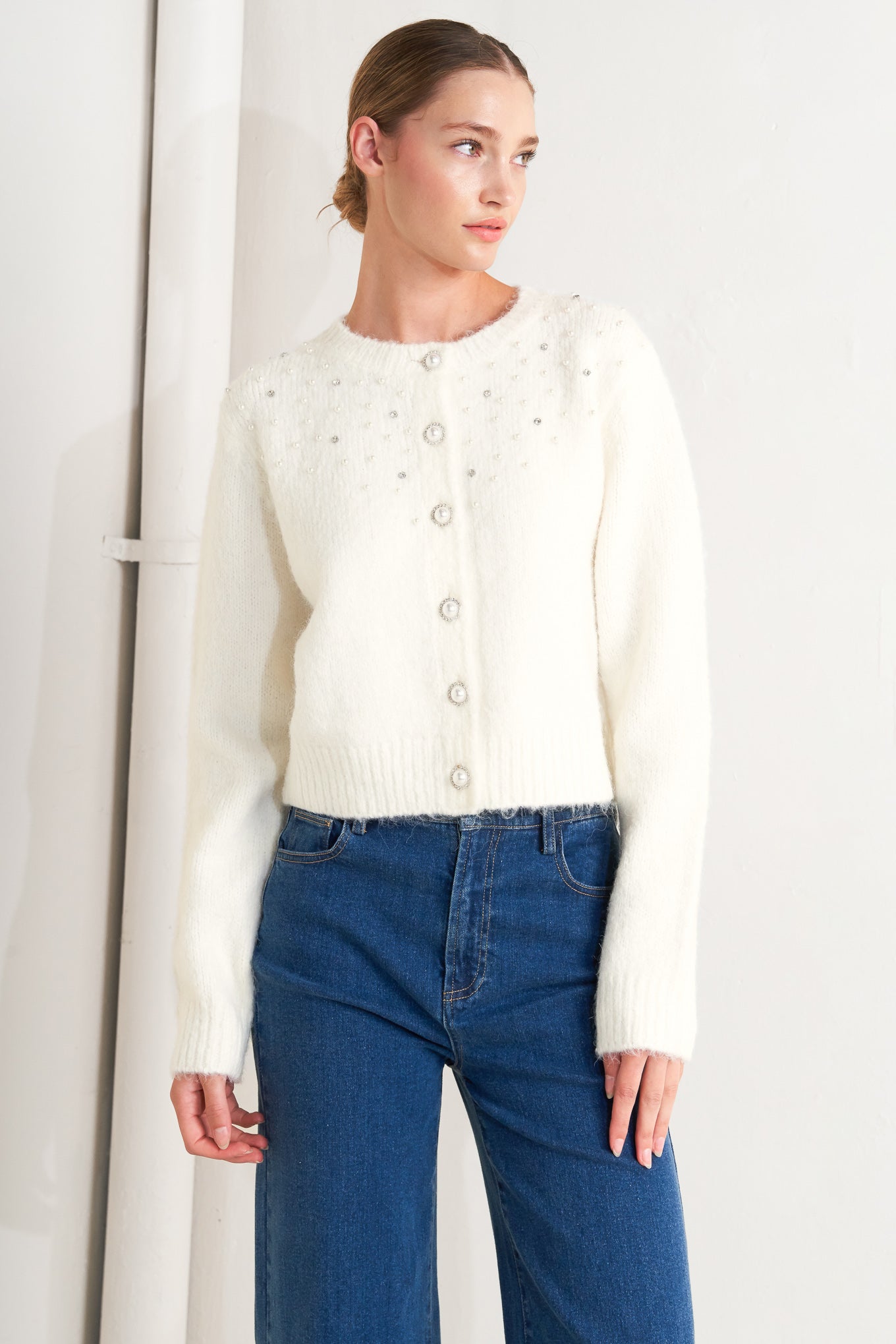 A sweater knit cardigan featuring round neckline, long sleeve and jewel embellishment and button