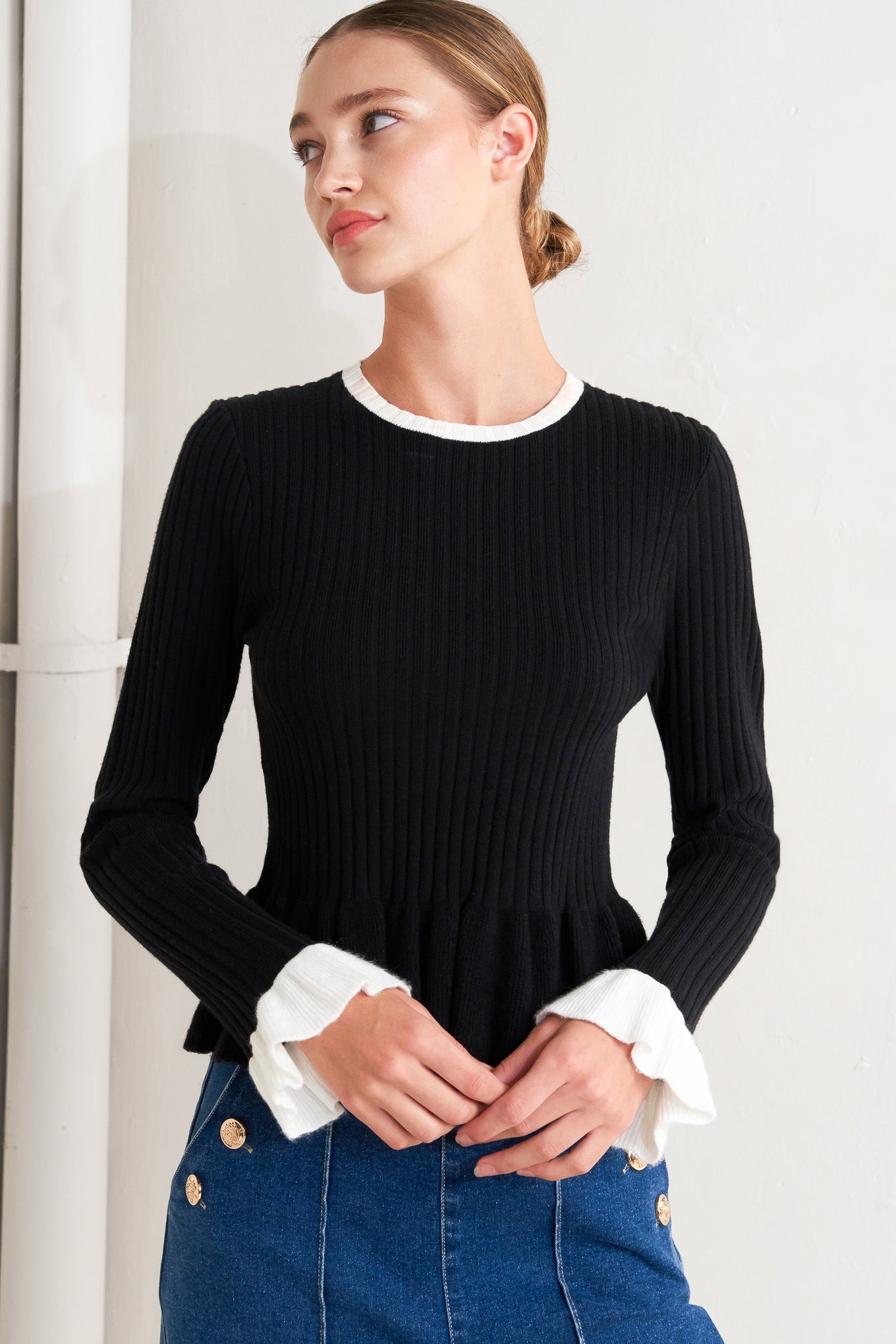 A sweater knit top featuring round neckline, long sleeve with ruffled sleeve and ruffled peplum