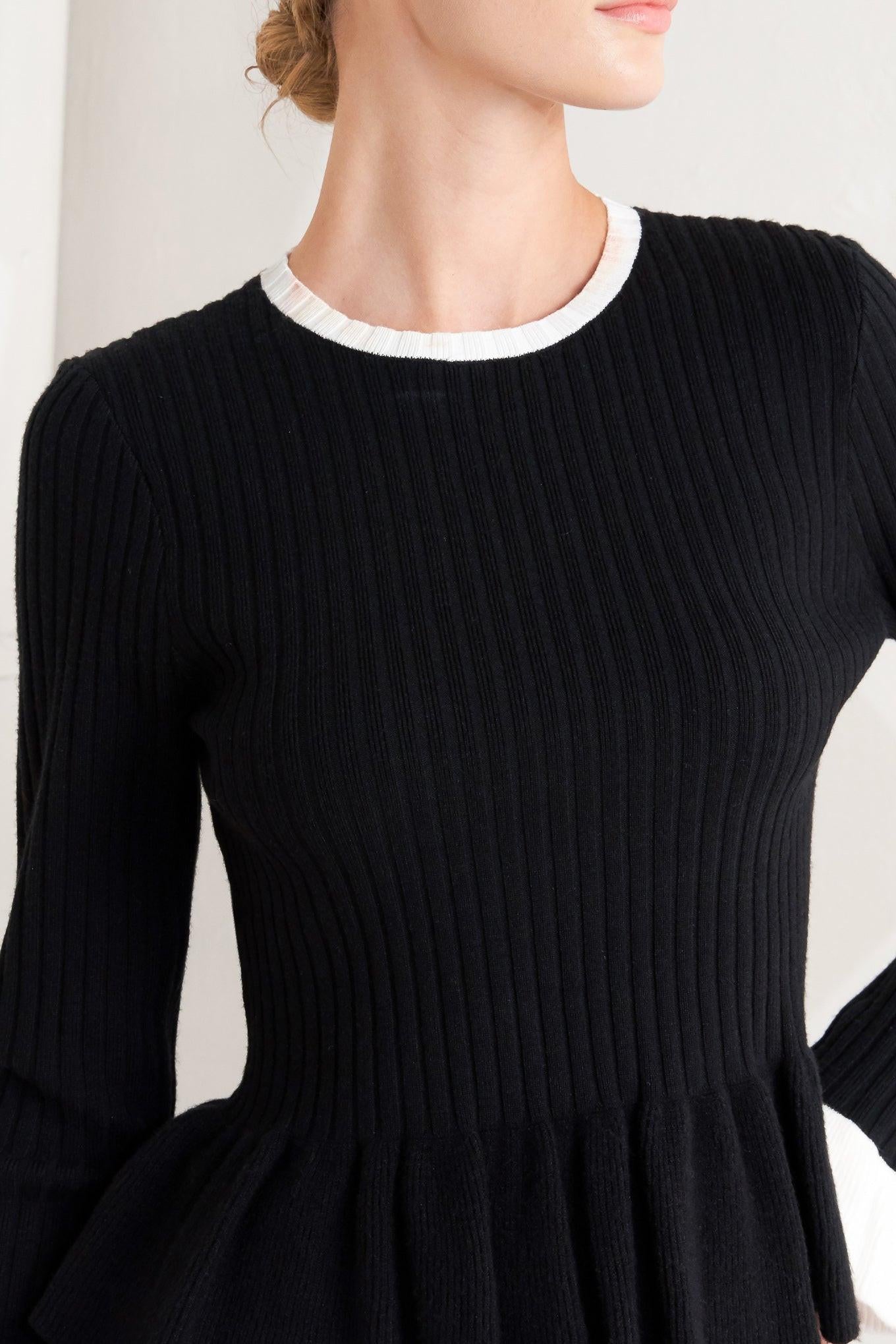 A sweater knit top featuring round neckline, long sleeve with ruffled sleeve and ruffled peplum