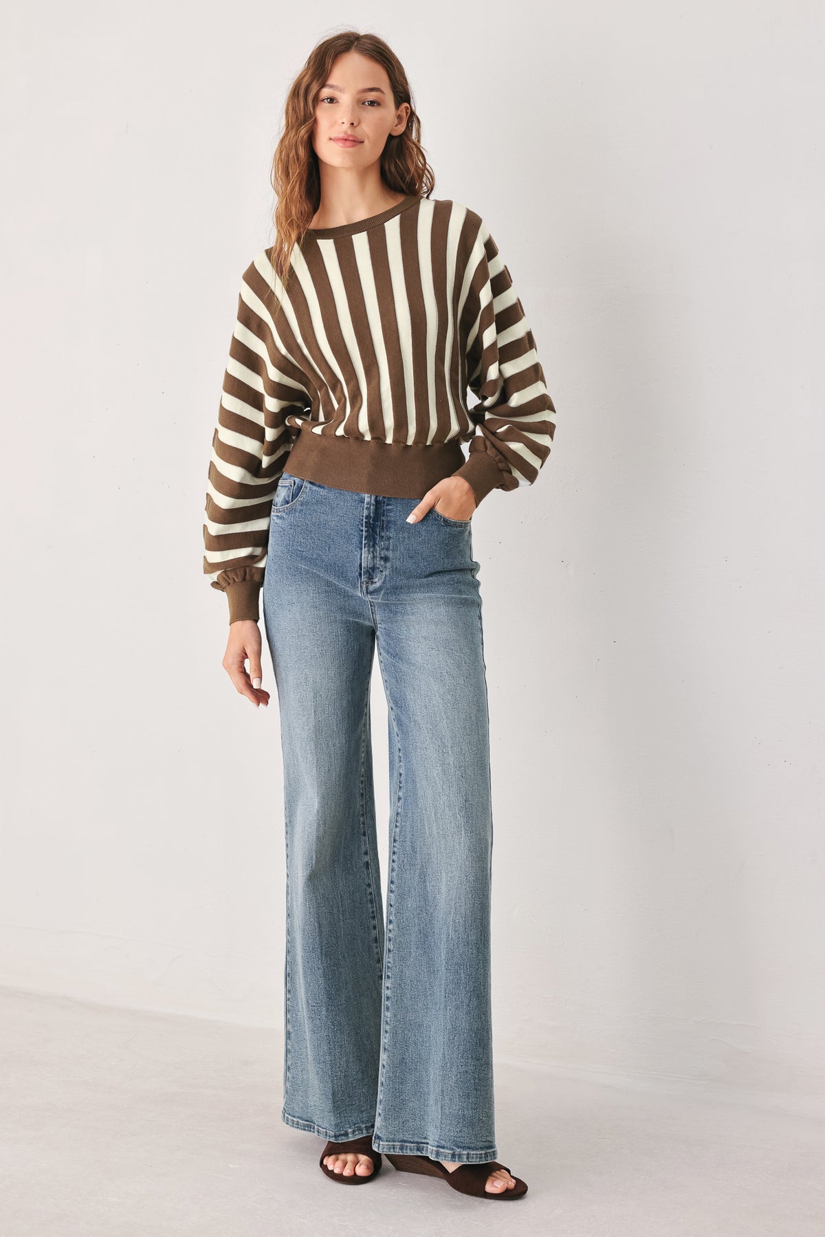 A woman wearing a brown and ivory striped long-sleeve knit top | FREEMARKET