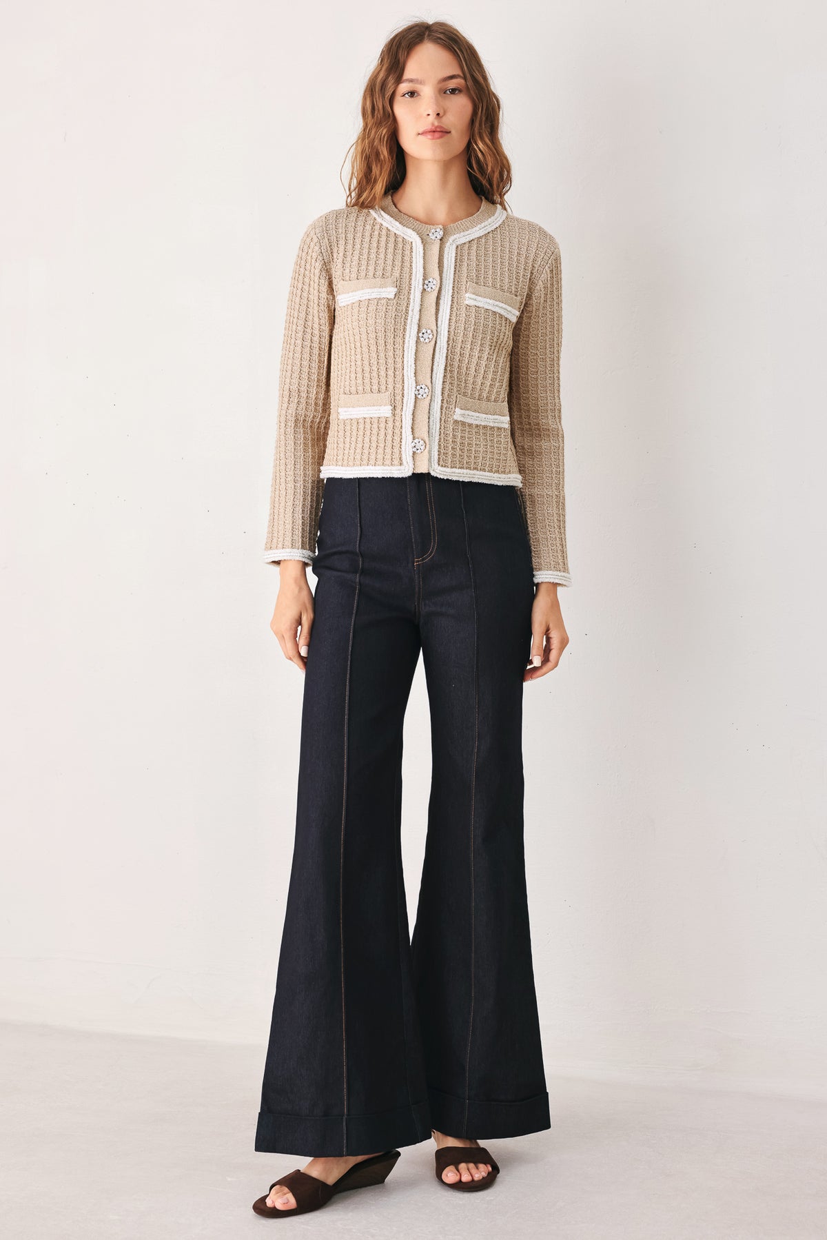 A woman wearing a beige textured knit cardigan with white trim and decorative buttons | FREEMARKET
