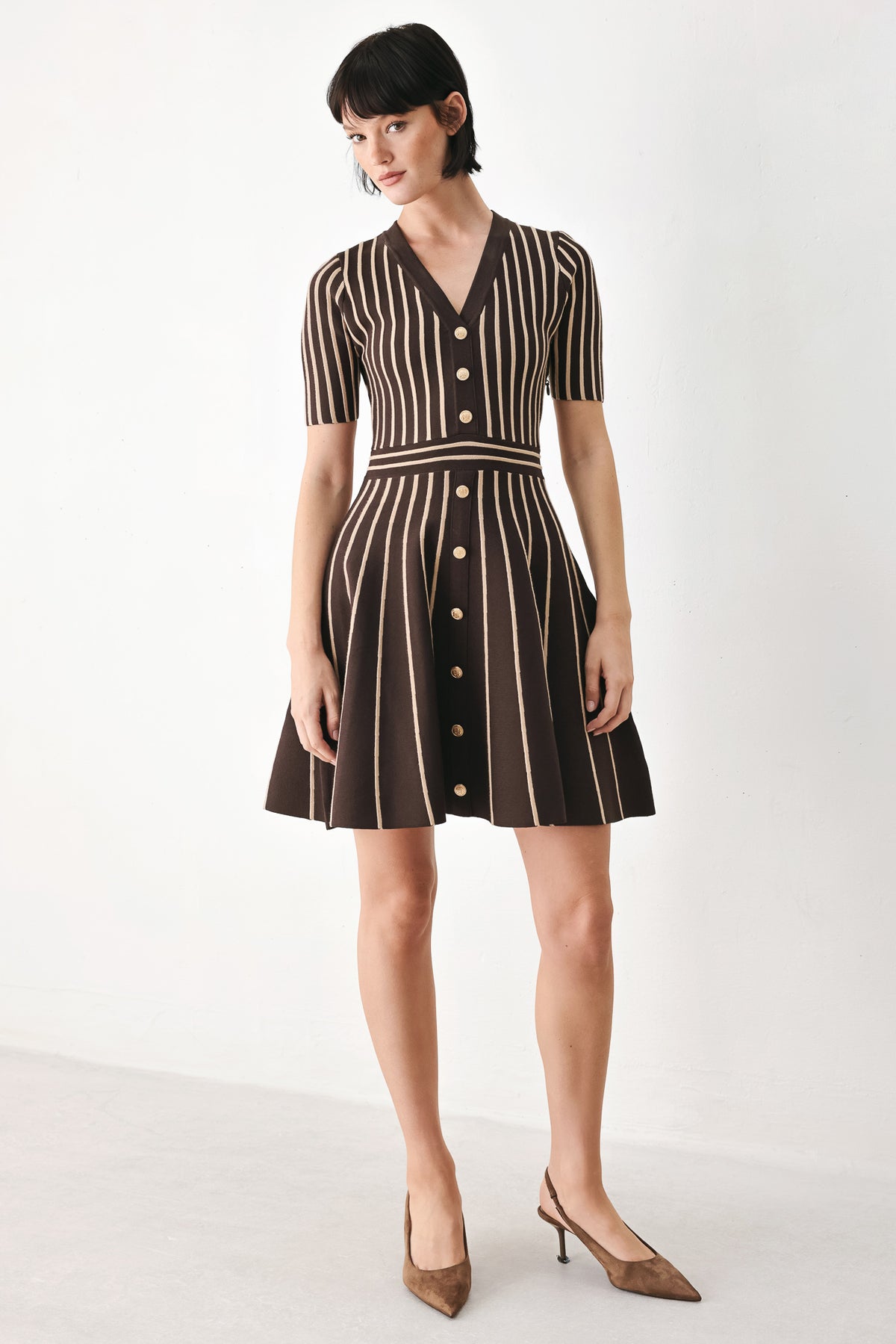 A woman modeling a short-sleeve V-neck dress with vertical brown and beige stripes, a buttoned front, and a flared skirt | FREEMARKET