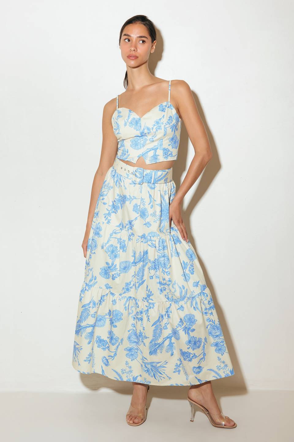 A printed woven cropped cami top with back zipper closure. Matching tiered skirt with back zipper closure.