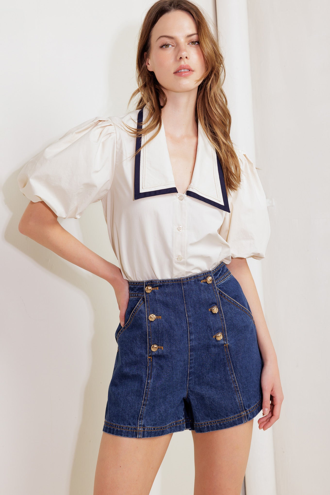 A solid woven top featuring collar, short bubble sleeve and button down