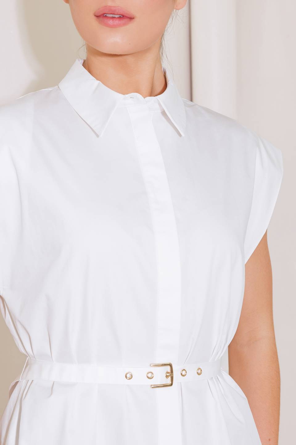 A solid woven top featuring collar, button down, short sleeve and self belt