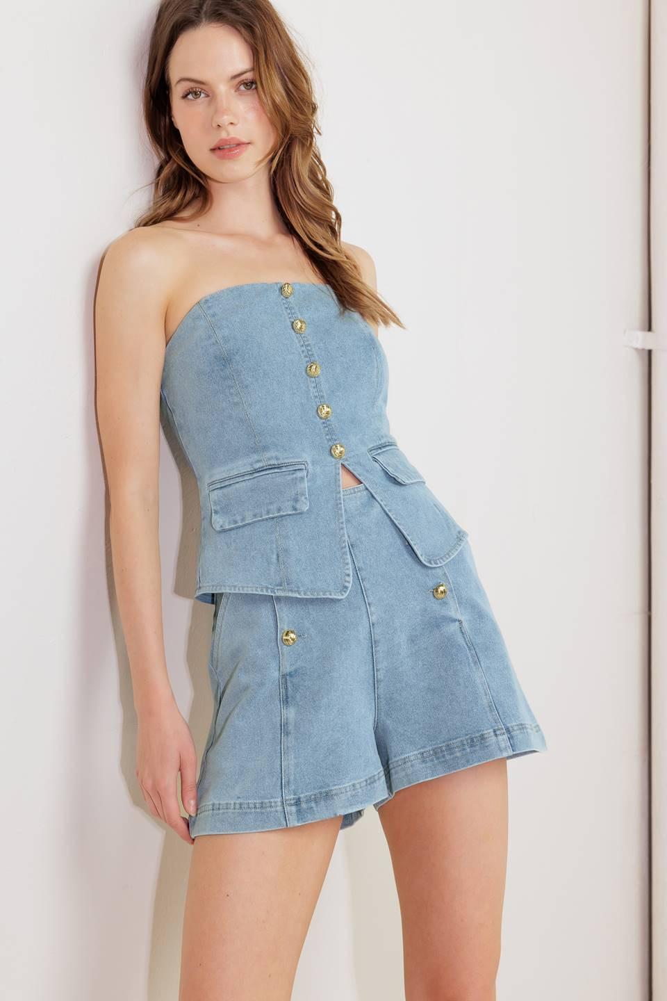 A washed denim top featuring strapless, front button-down detail and back zipper closure.