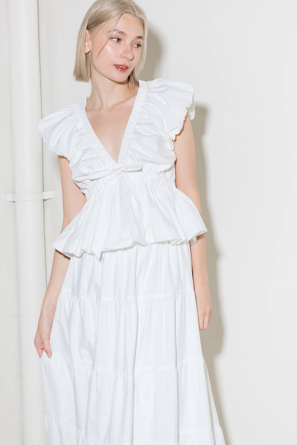 A solid woven top featuring V neckline, short bubble sleeve, elasticized at empire and bubble hemline.