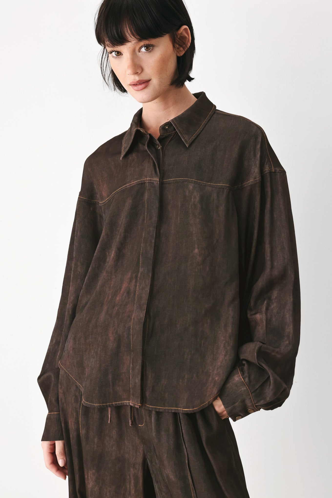 A model wearing a dark brown, washed-out button-up shirt | FREEMARKET