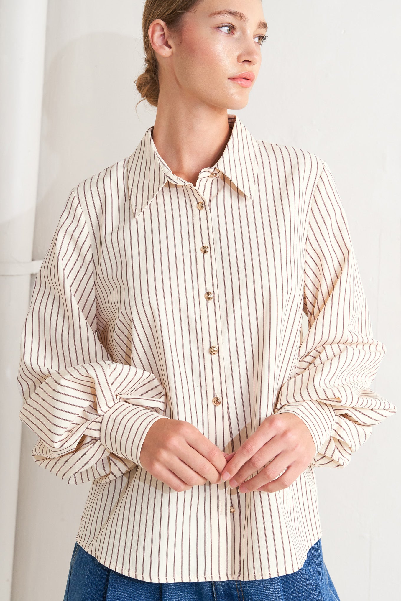 A striped woven top featuring collar, long sleeve and front button down