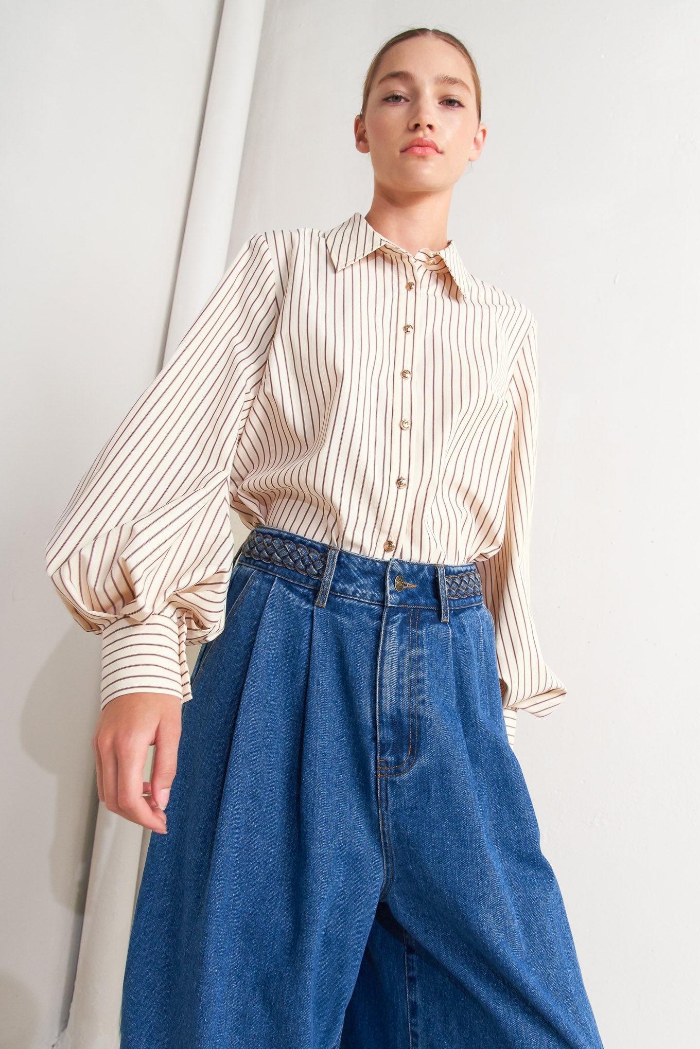 A striped woven top featuring collar, long sleeve and front button down